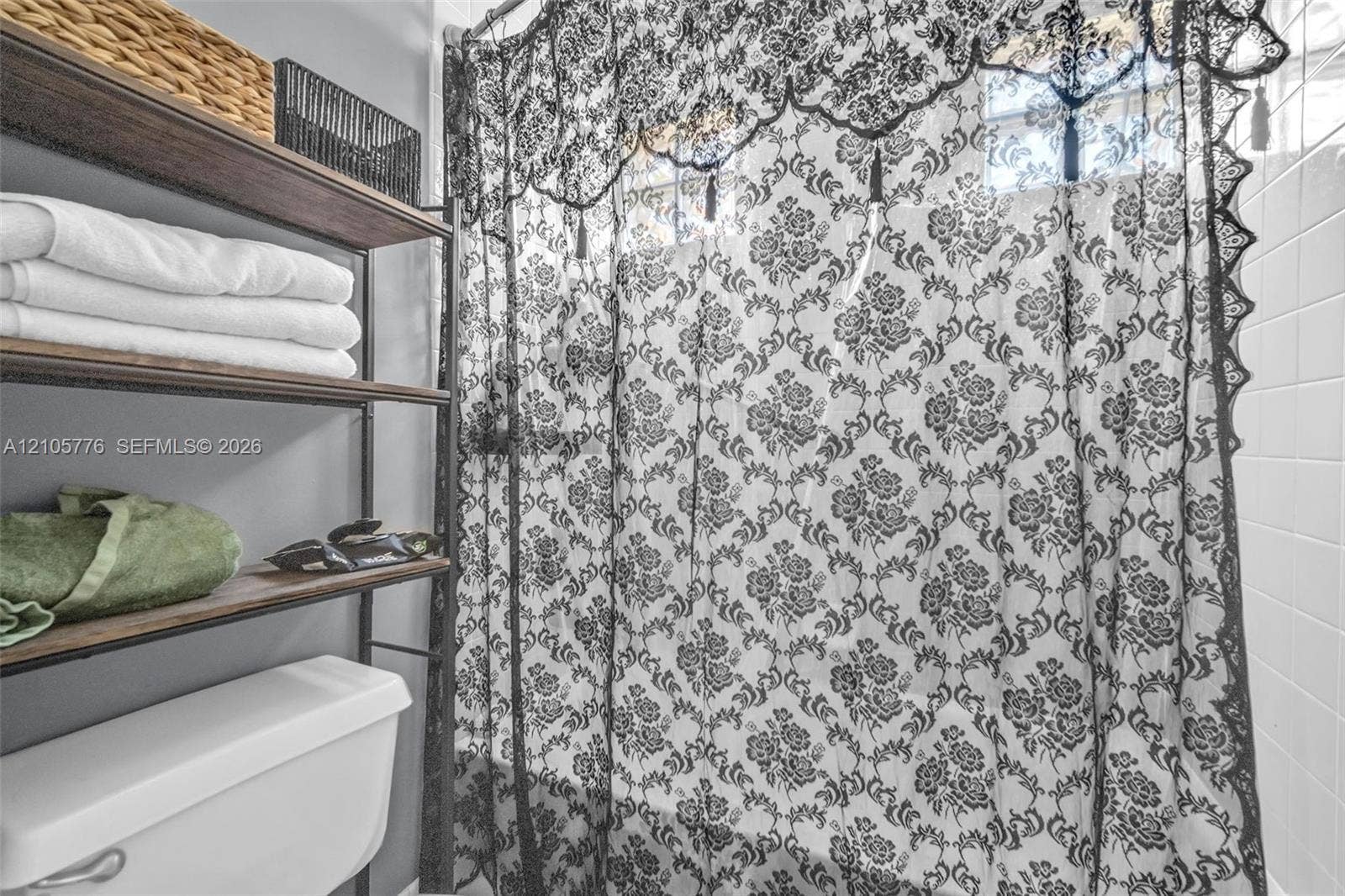 White ceramic tile surround and standard white toilet