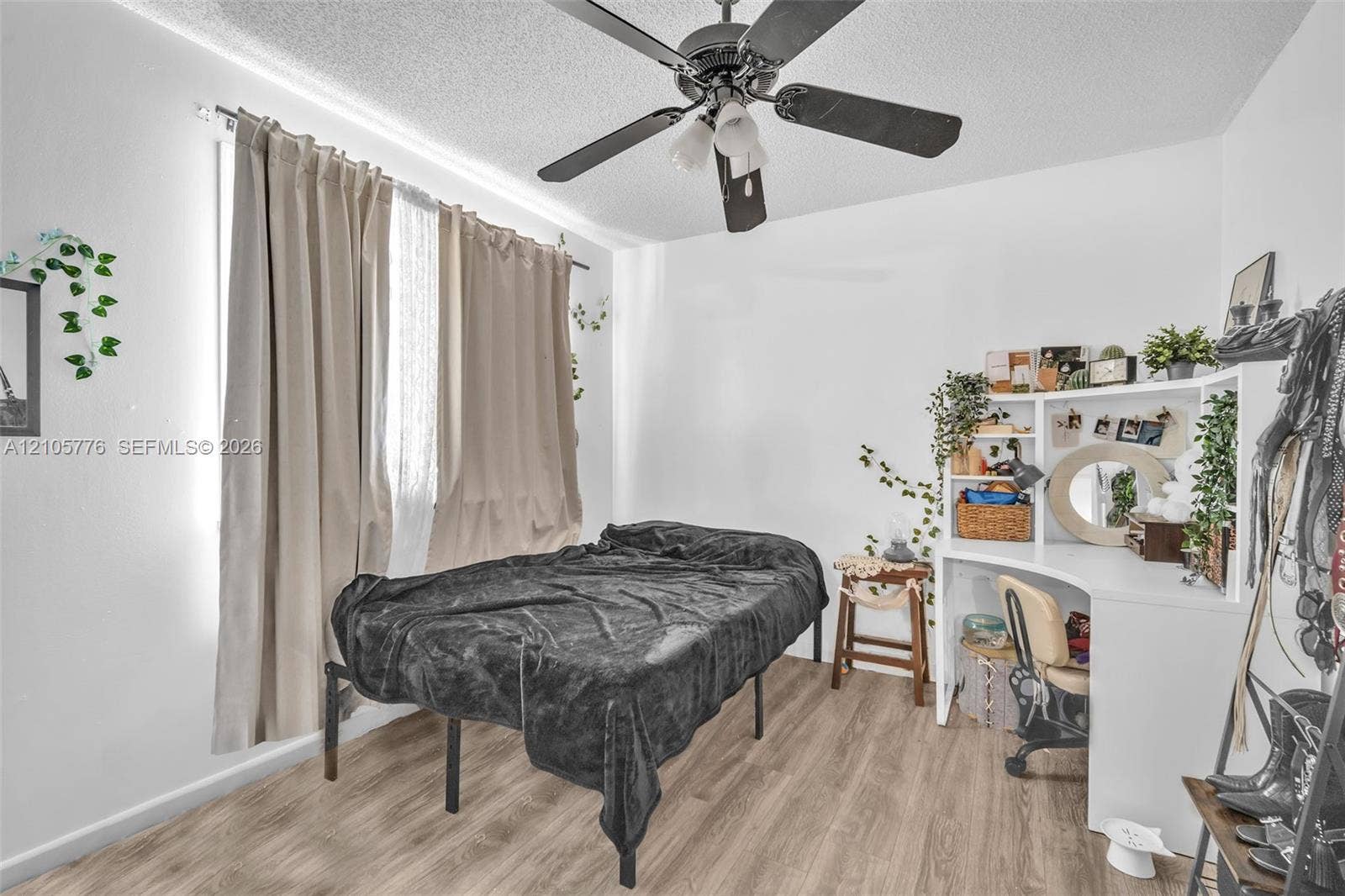 Wood-finish flooring, ceiling fan with integrated lighting, and built-in white corner desk cabinetry