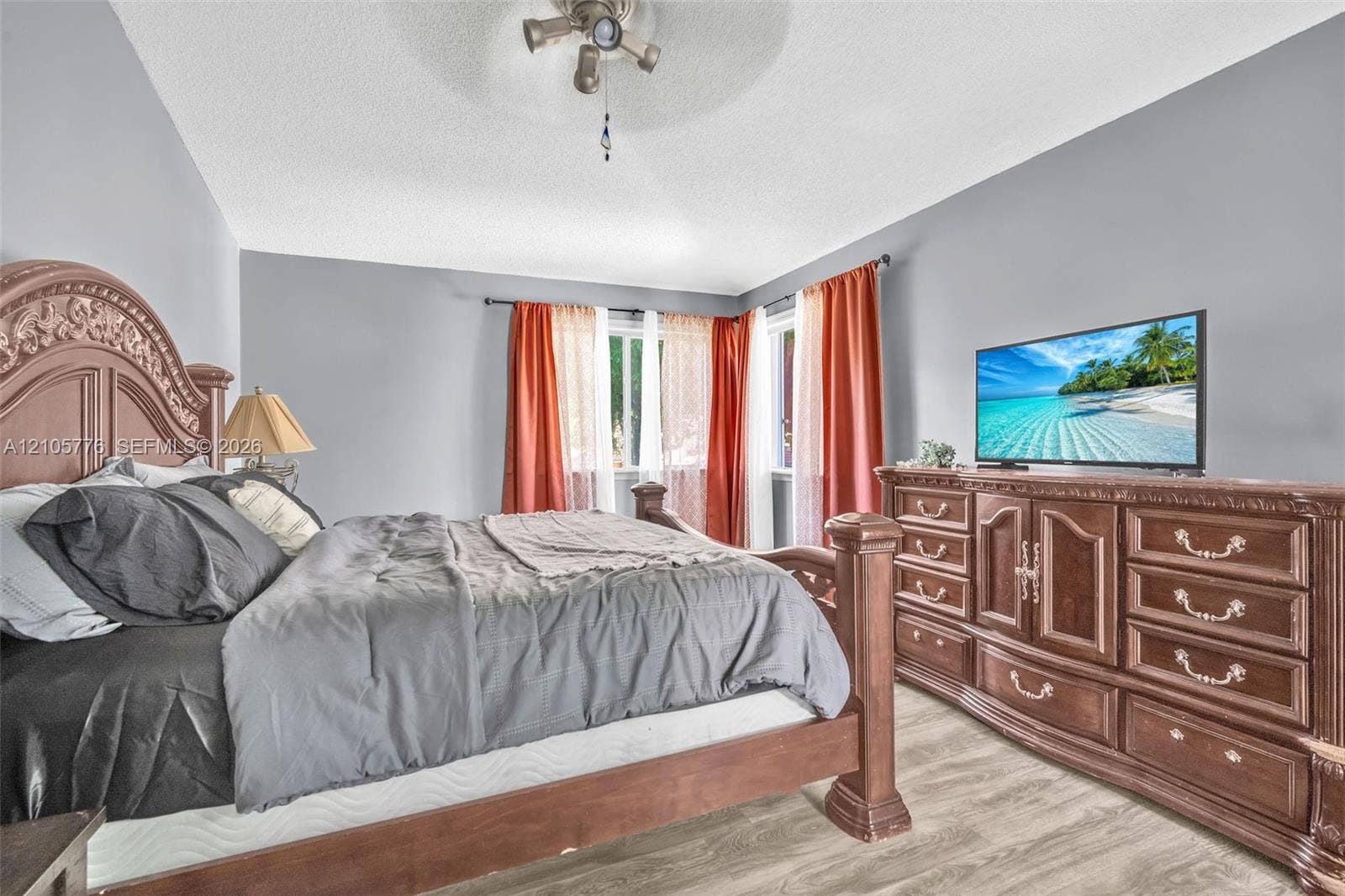Room featuring neutral wall paint, wood-finish flooring, and a multi-light ceiling fan