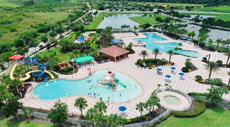 Community amenity center featuring multi-level swimming pools, water slides, a splash pad, and a poolside pavilion