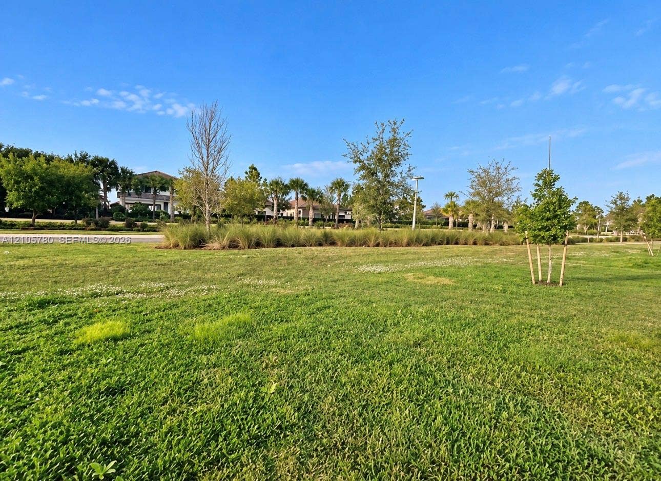 Expansive parcel featuring open green space, manicured grass, and mature landscape plantings