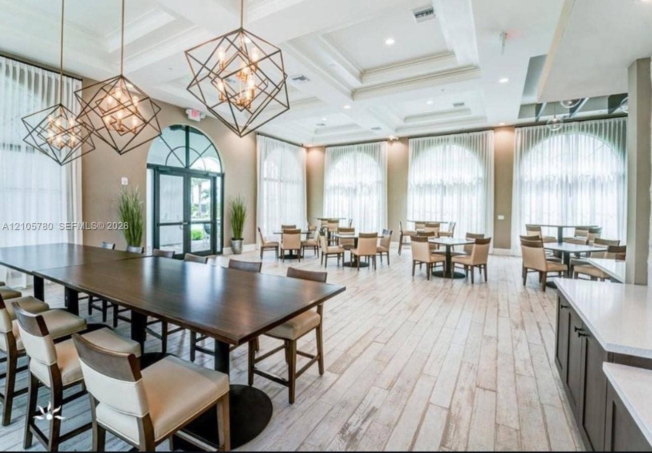 Coffered ceilings, geometric pendant lighting, arched windows, and wood-finish flooring