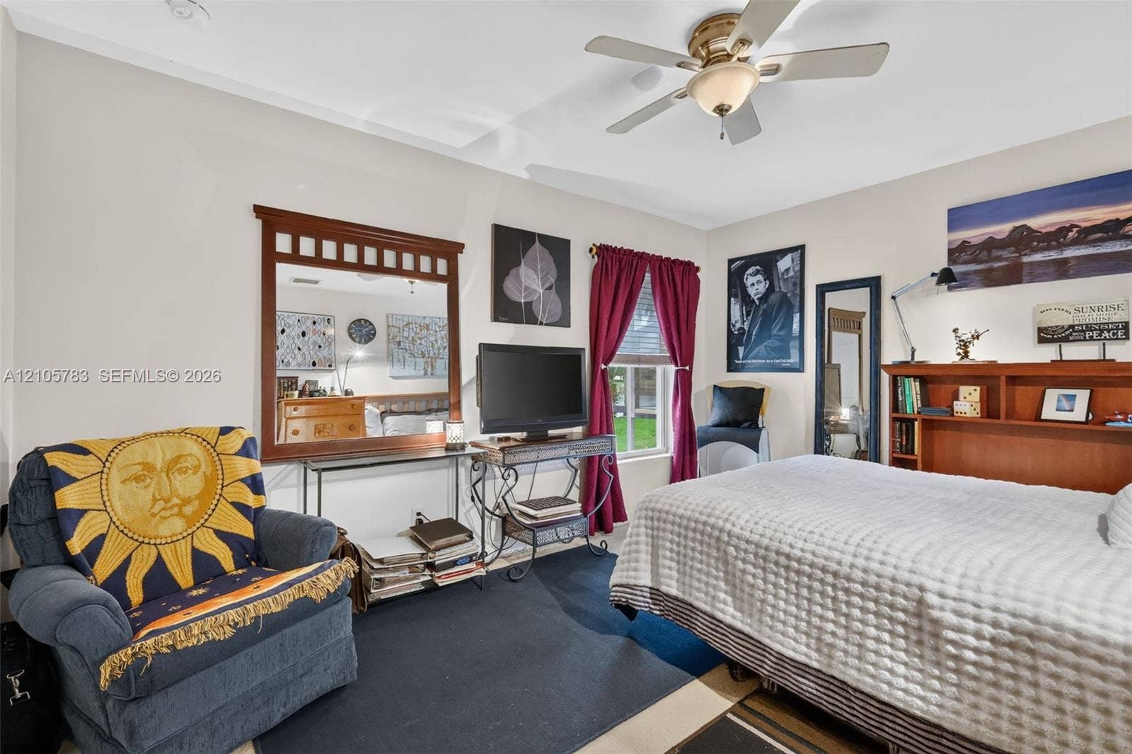 Neutral-toned interior featuring a ceiling fan with integrated lighting and a window with wood-frame trim