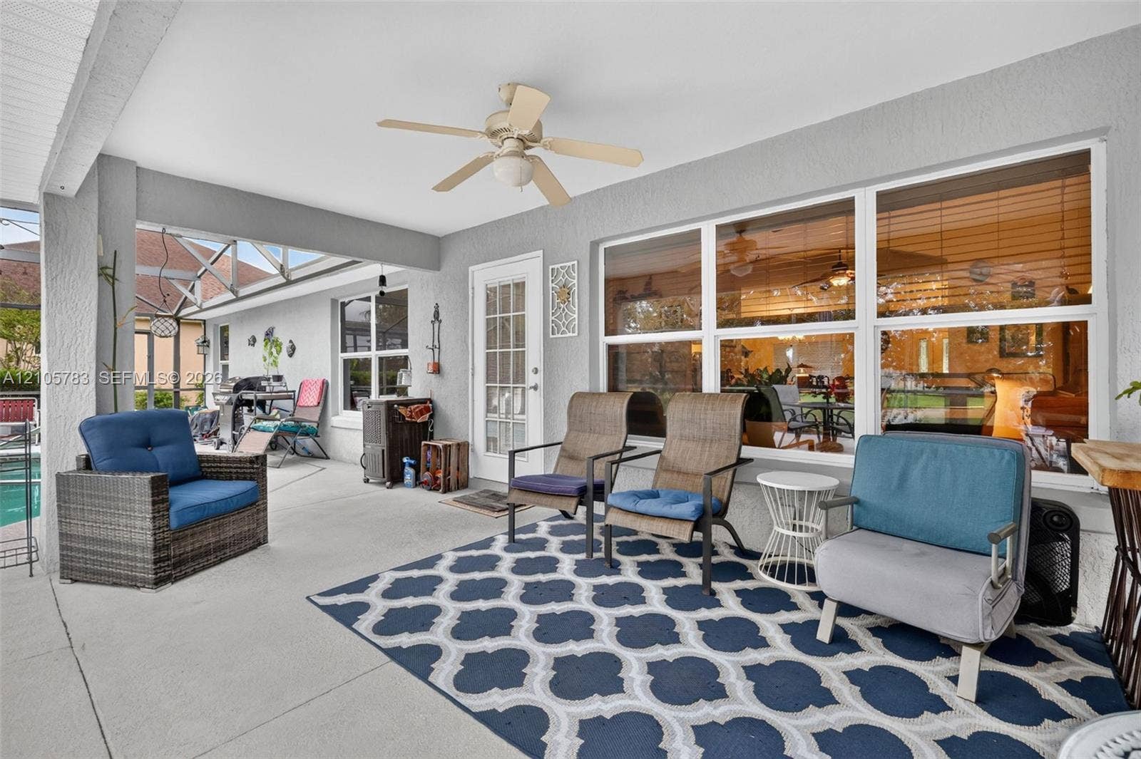 Covered outdoor patio with a concrete floor, ceiling fan, and large windows