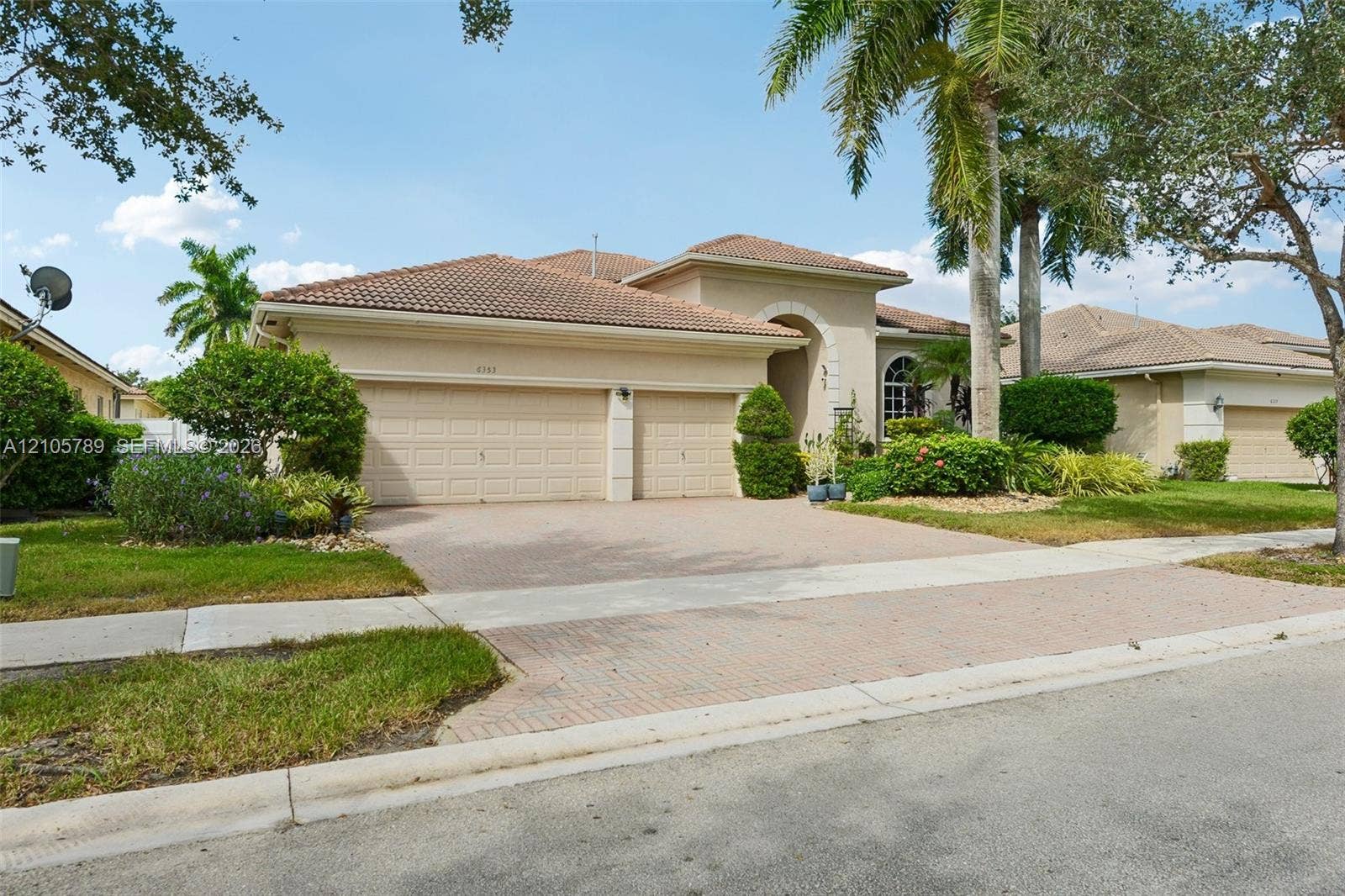 6353 SW 191st Avenue, Pembroke Pines, FL 33332 Stucco exterior featuring a tile roof, arched entryway, and multi-car garage with paver driveway