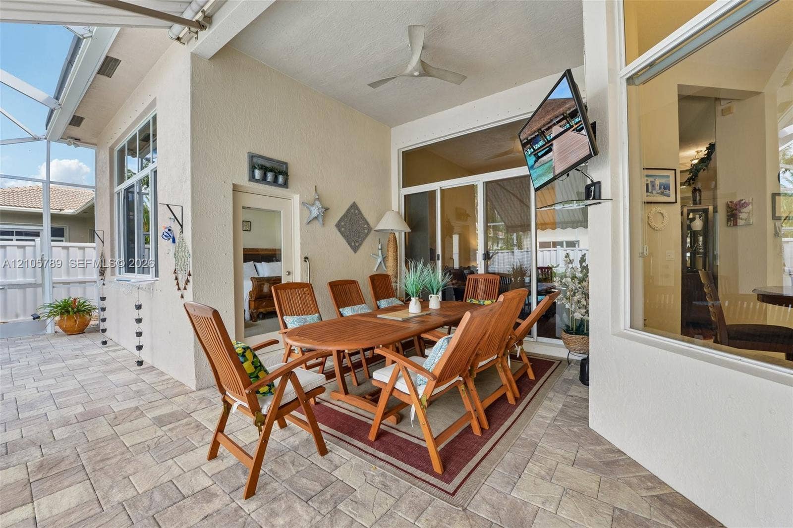 6353 SW 191st Avenue, Pembroke Pines, FL 33332 Covered lanai featuring paver flooring, a ceiling fan, and large sliding glass doors