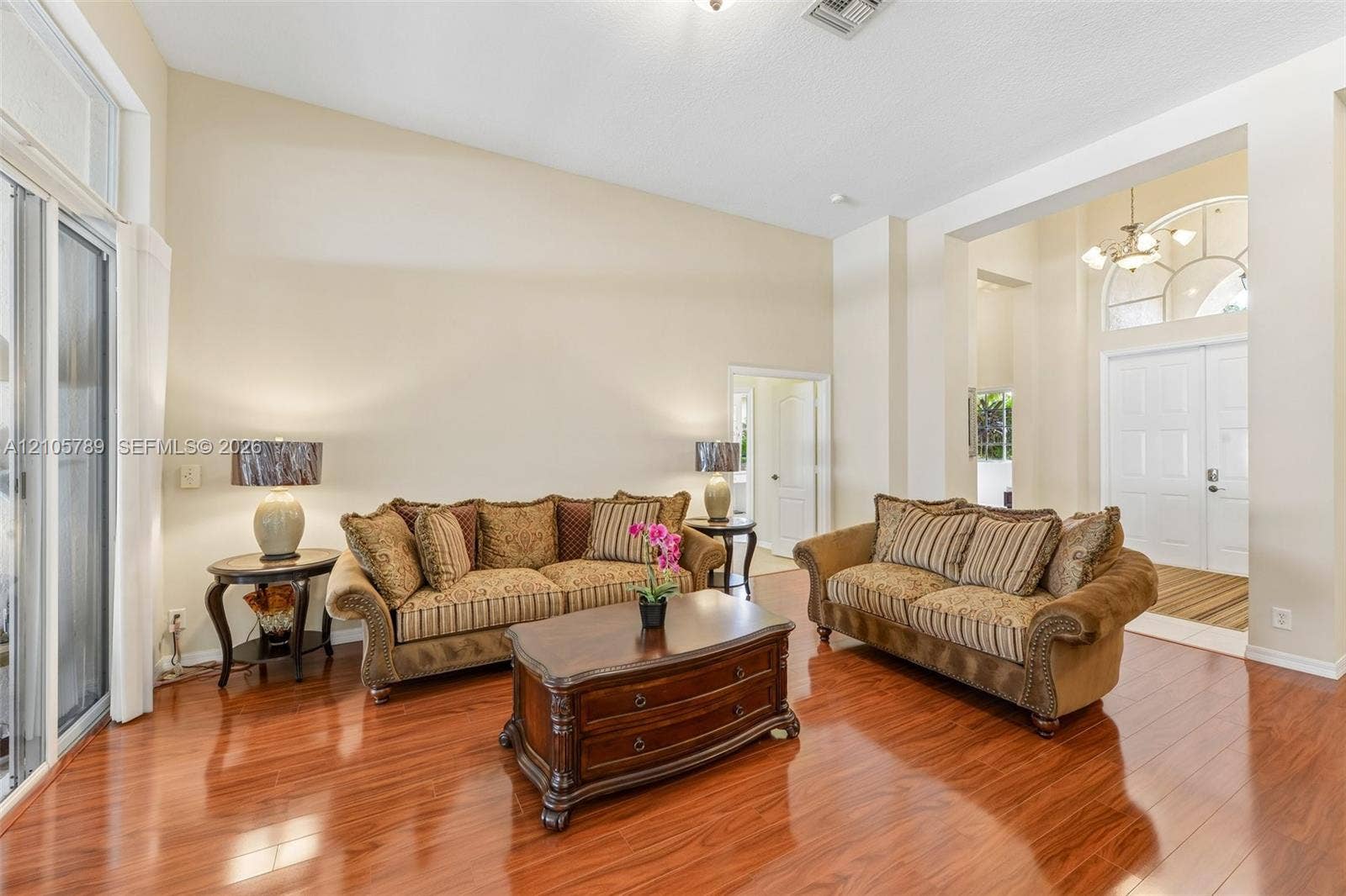 6353 SW 191st Avenue, Pembroke Pines, FL 33332 High-ceiling interior featuring wood-finish flooring, recessed lighting, double-door entry with an arched transom window, and sliding glass doors
