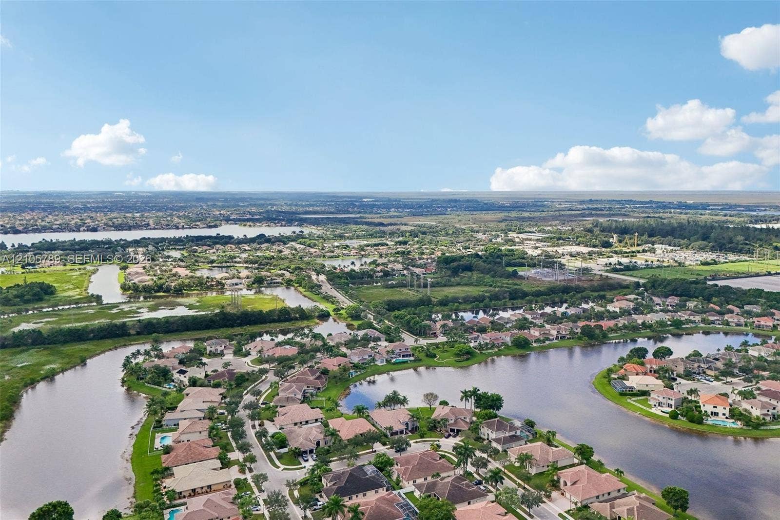 6353 SW 191st Avenue, Pembroke Pines, FL 33332 Aerial perspective featuring expansive waterway frontage, mature landscaping, and multi-family residential parcels