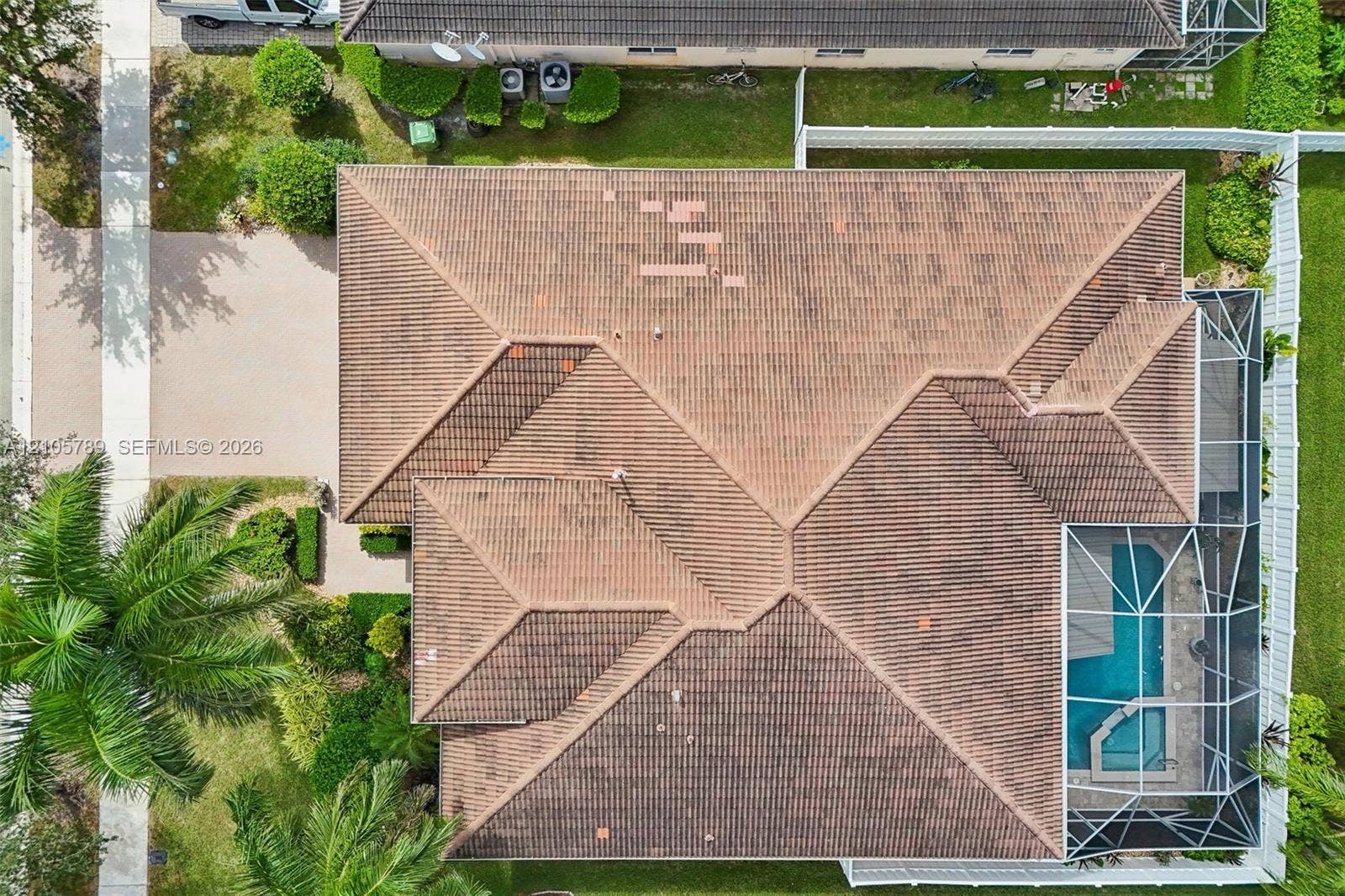 6353 SW 191st Avenue, Pembroke Pines, FL 33332 Aerial perspective of property featuring a tile roof, paved driveway, enclosed pool area, and perimeter fencing