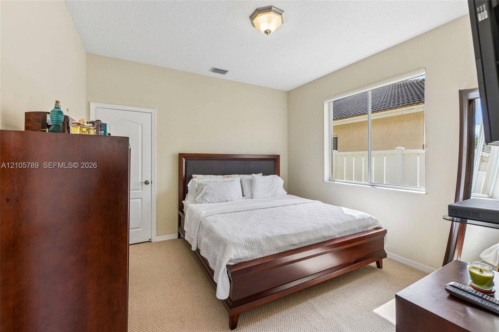 6353 SW 191st Avenue, Pembroke Pines, FL 33332 Neutral-toned interior room with wall-to-wall carpeting, a multi-pane sliding window, and a single-panel interior door