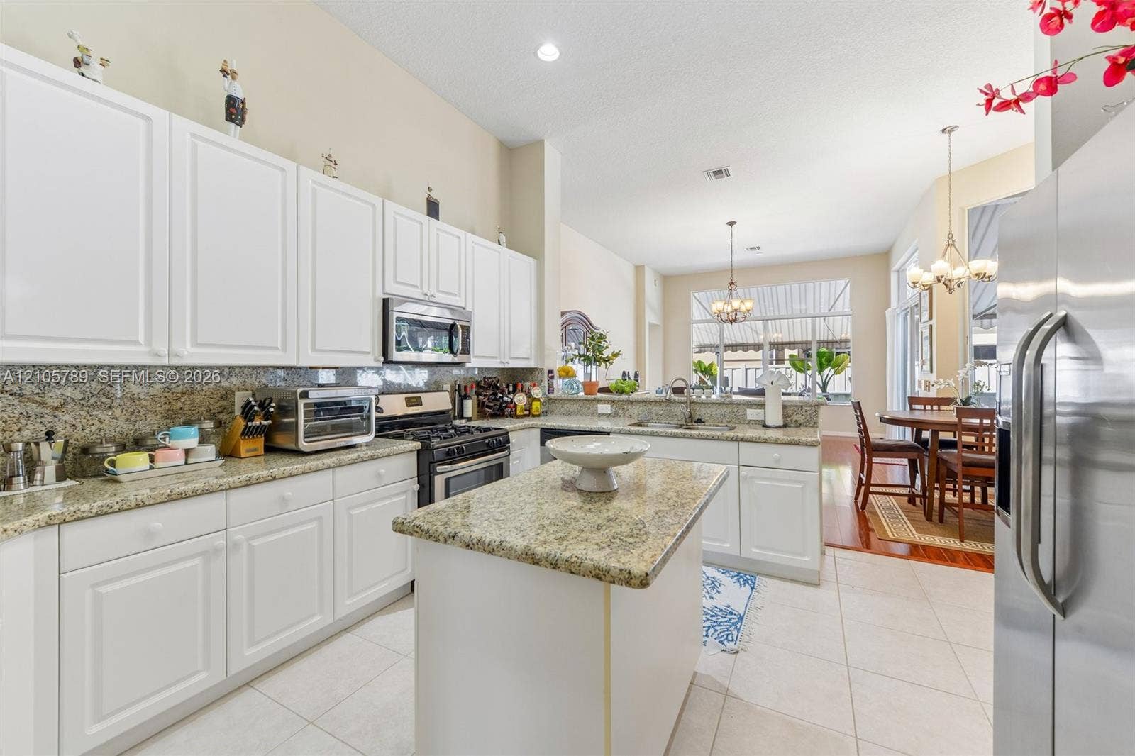 6353 SW 191st Avenue, Pembroke Pines, FL 33332 Kitchen featuring white shaker-style cabinetry, stone countertops, a center island, and stainless steel appliances