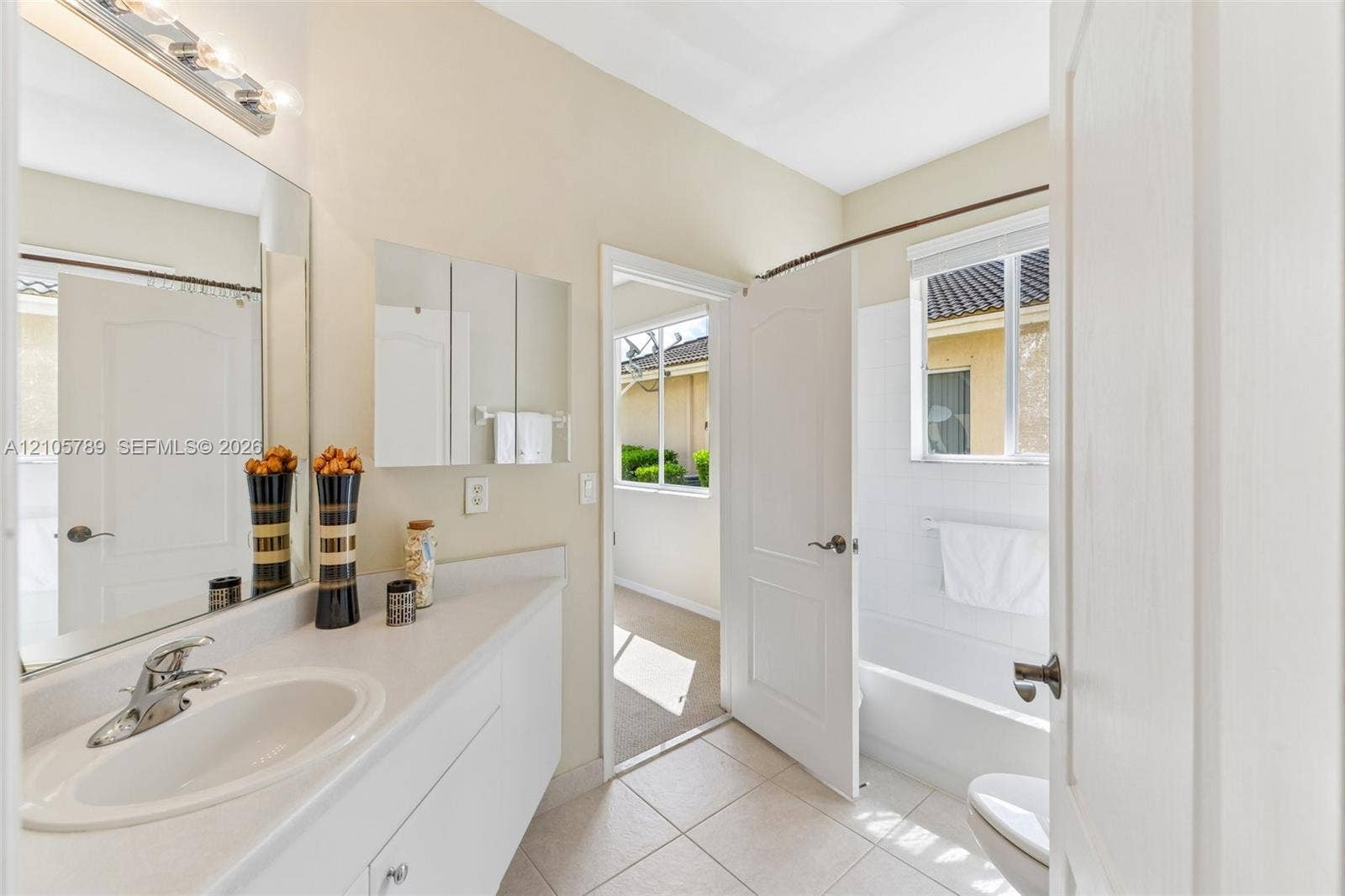 6353 SW 191st Avenue, Pembroke Pines, FL 33332 Bathroom featuring a vanity with a white solid-surface countertop, an integrated oval basin, a chrome faucet, and a large wall-mounted mirror
