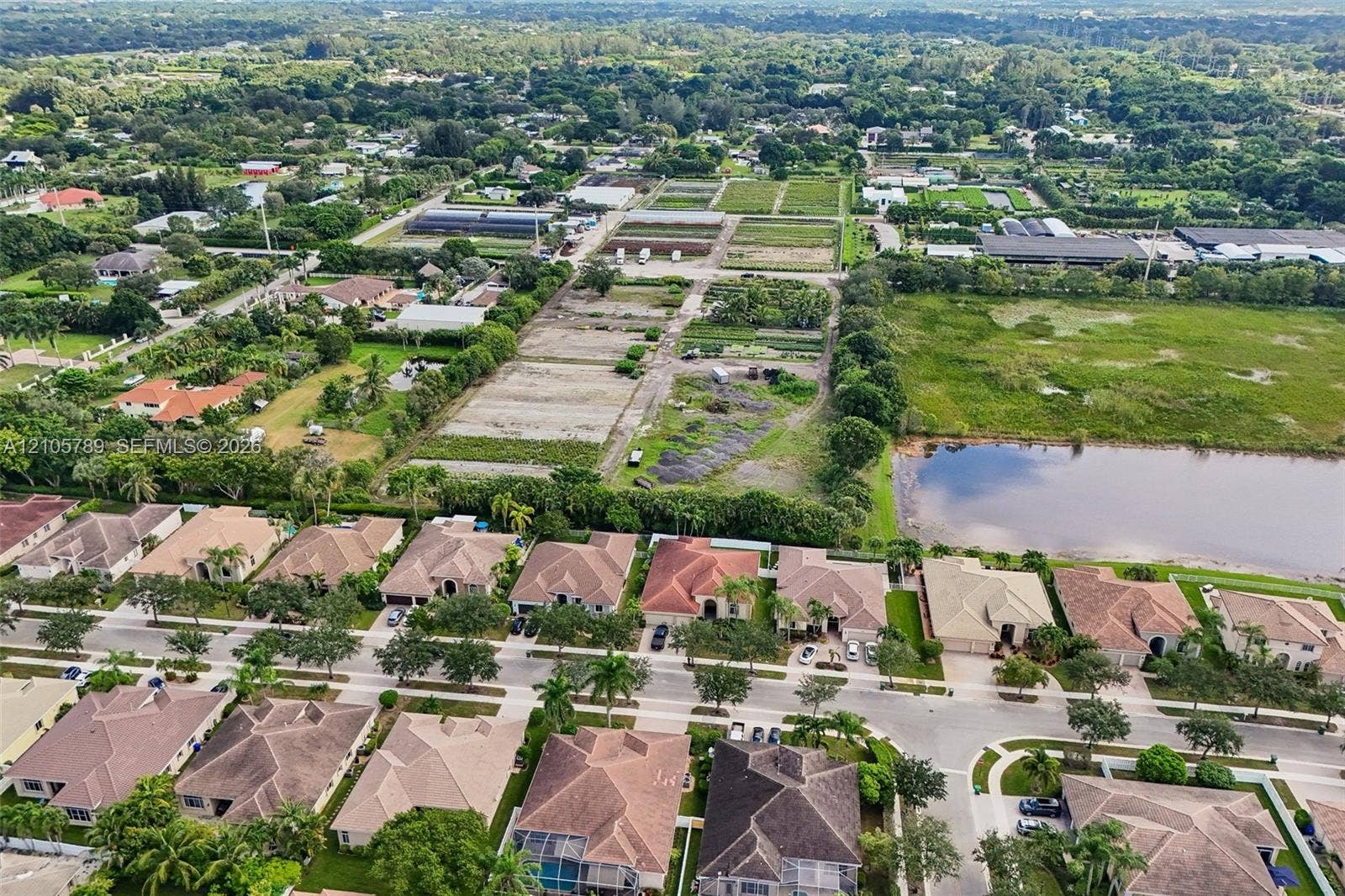6353 SW 191st Avenue, Pembroke Pines, FL 33332 Aerial perspective featuring residential lots with pitched tile roofing, concrete sidewalks, established tropical landscaping, and a natural retention pond