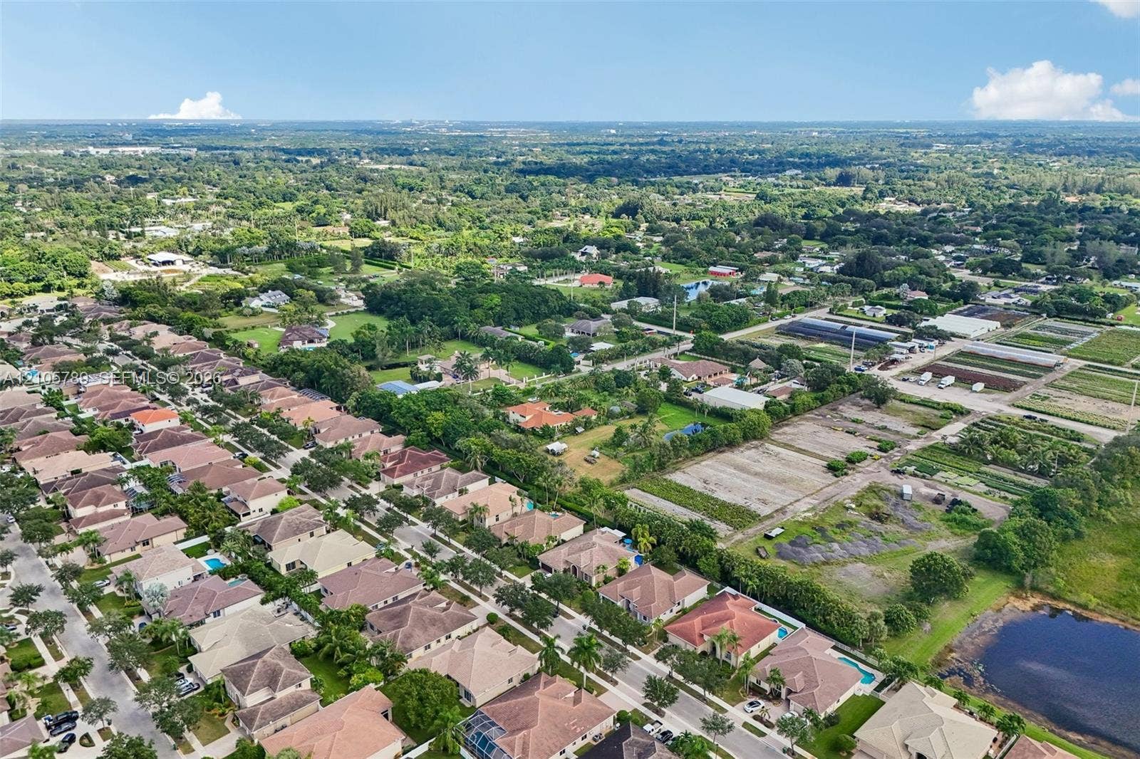 6353 SW 191st Avenue, Pembroke Pines, FL 33332 Aerial perspective of a suburban neighborhood featuring residential homes with tile roofing, mature landscaping, paved street infrastructure, and proximity to open green space and a retention pond