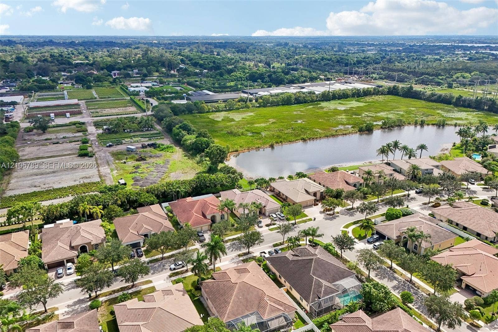 6353 SW 191st Avenue, Pembroke Pines, FL 33332 Aerial perspective of a residential community featuring multi-hipped tile rooflines and proximity to a central pond