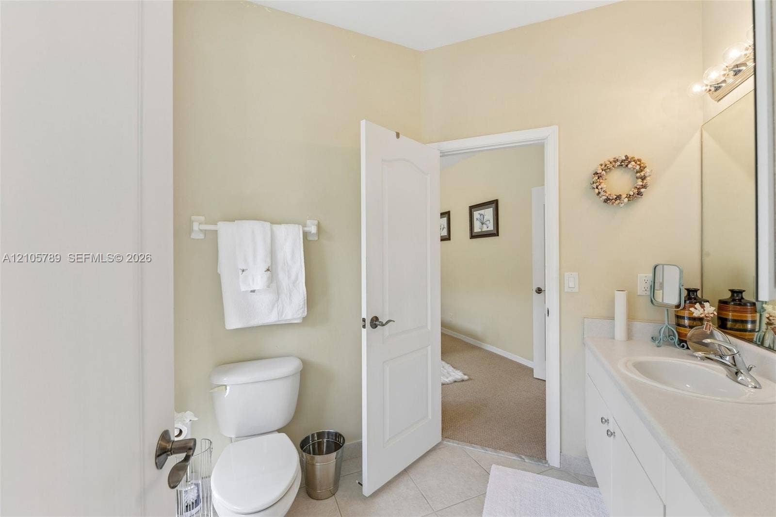 6353 SW 191st Avenue, Pembroke Pines, FL 33332 Bathroom featuring a vanity with an integrated basin, a large wall-mounted mirror, a polished chrome-finish faucet, and tile flooring
