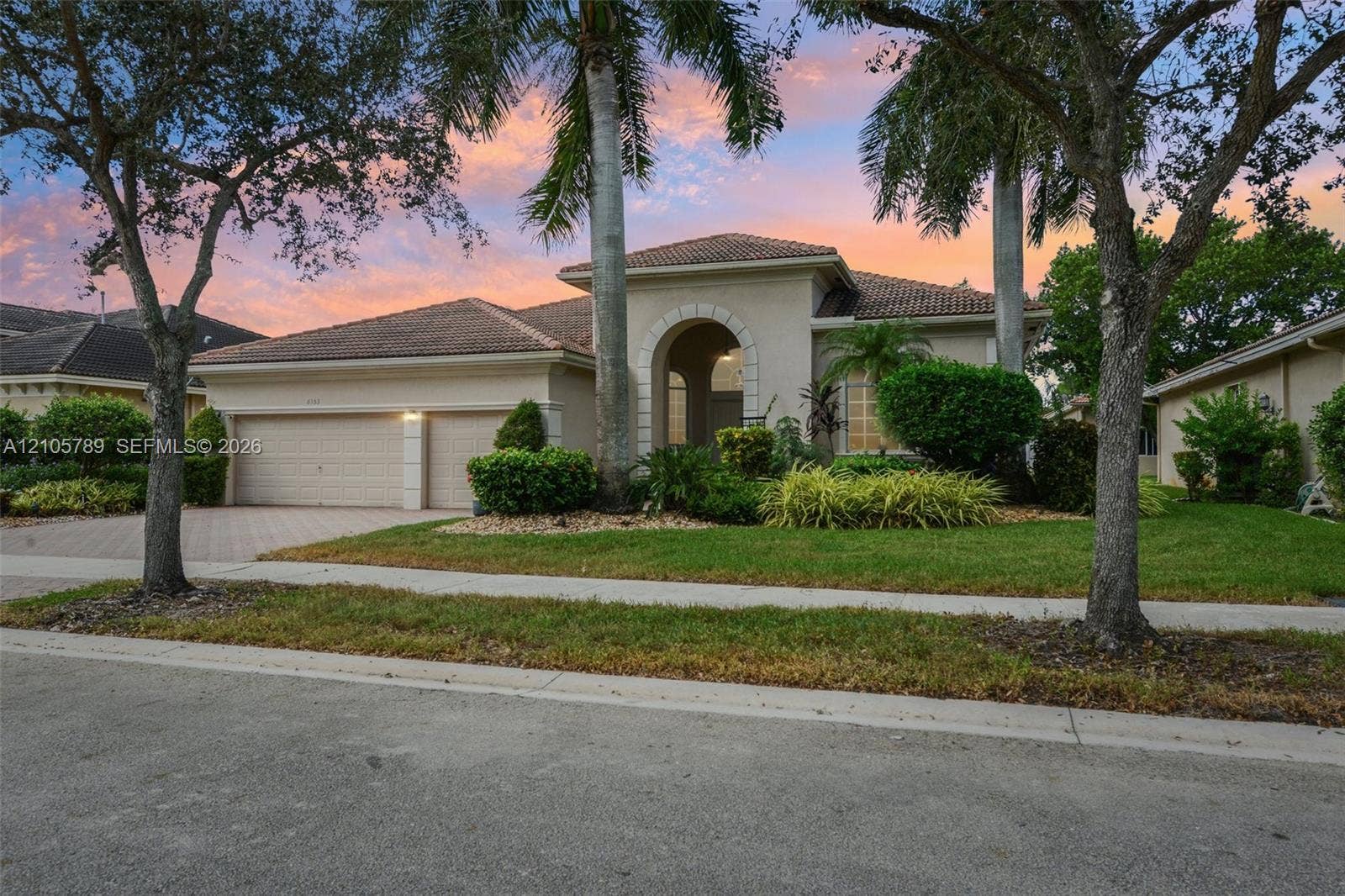 6353 SW 191st Avenue, Pembroke Pines, FL 33332 Stucco exterior featuring a tiled roof, arched entryway, paved driveway, and attached two-car garage