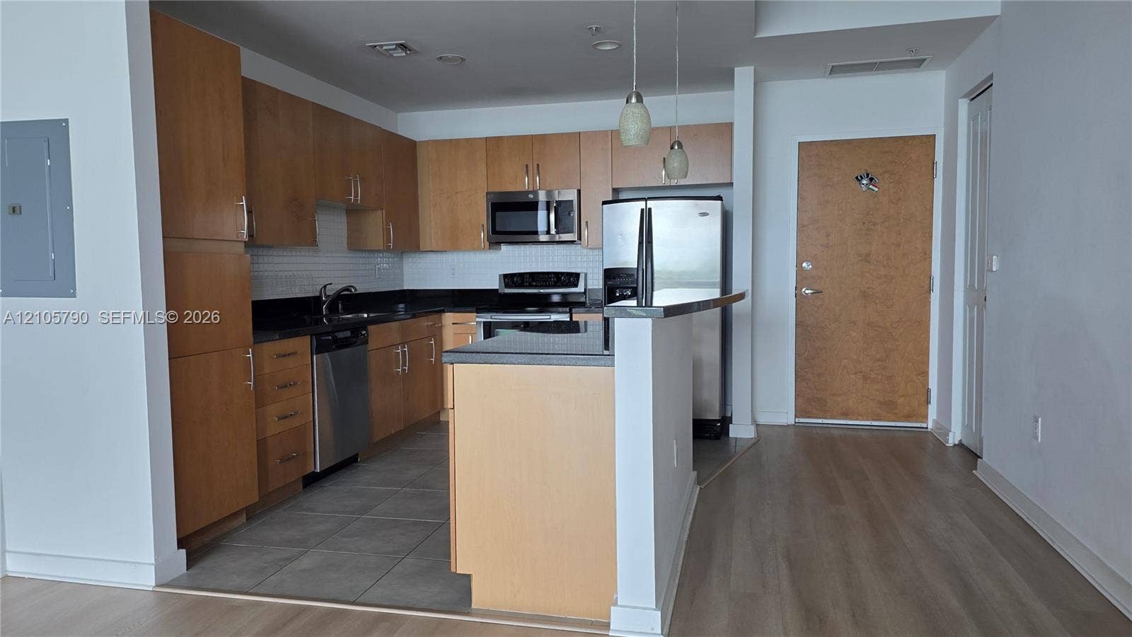 300 S Australian Avenue, #426, West Palm Beach, West Palm Beach, FL 33401 Kitchen featuring wood-finish cabinetry, dark solid-surface countertops, stainless steel appliances, tile flooring, and two pendant lights