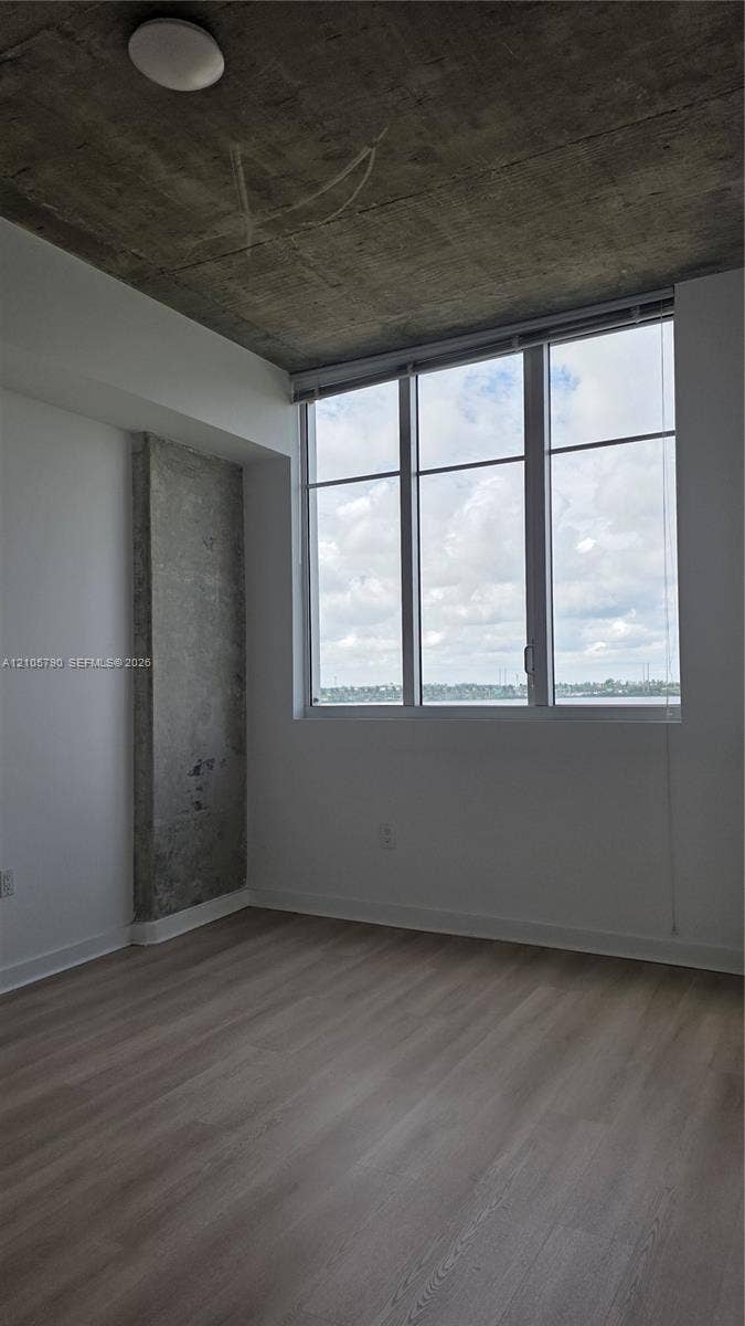 300 S Australian Avenue, #426, West Palm Beach, West Palm Beach, FL 33401 Exposed concrete ceiling and structural pillar, floor-to-ceiling windows, and wood-finish flooring
