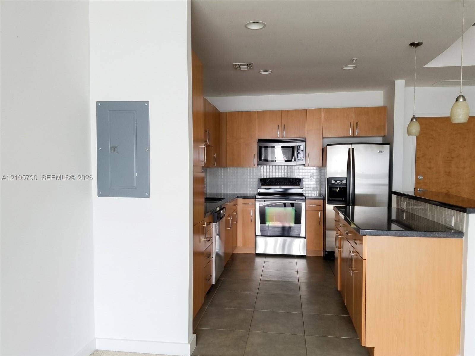300 S Australian Avenue, #426, West Palm Beach, West Palm Beach, FL 33401 Kitchen featuring light wood-finish cabinetry, stainless steel appliances, dark stone countertops, tile backsplash, and oversized ceramic floor tiles
