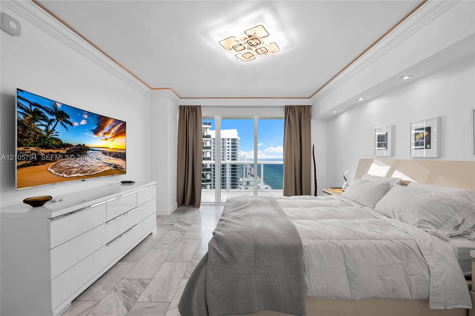1830 S Ocean Drive, #4210, Hallandale Beach, Hallandale Beach, FL 33009 Floor-to-ceiling glass balcony doors, stone-finish tile flooring, recessed ceiling lighting, contemporary geometric flush-mount light fixture, and crown molding