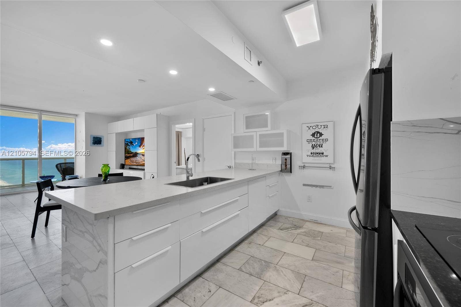 1830 S Ocean Drive, #4210, Hallandale Beach, Hallandale Beach, FL 33009 Kitchen featuring white cabinetry with stone-surface countertops, waterfall-edge island, undermount stainless steel sink, tile flooring, and integrated lighting