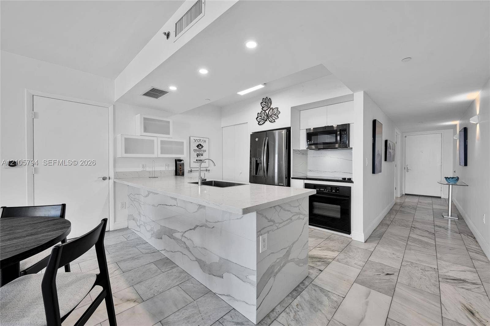 1830 S Ocean Drive, #4210, Hallandale Beach, Hallandale Beach, FL 33009 Kitchen featuring a quartz waterfall island, stone-finish tile flooring, white cabinetry, stainless steel appliances, and recessed lighting