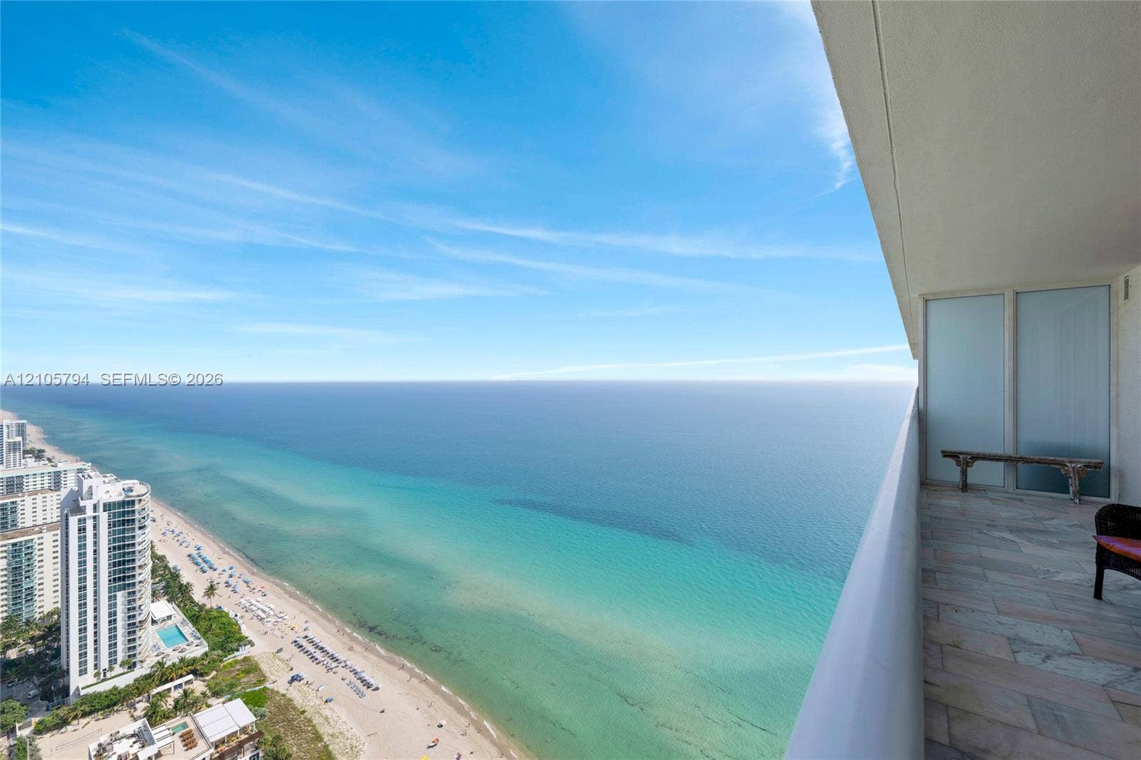1830 S Ocean Drive, #4210, Hallandale Beach, Hallandale Beach, FL 33009 Covered balcony featuring stone tile flooring, frosted glass privacy panel, and expansive ocean scenery