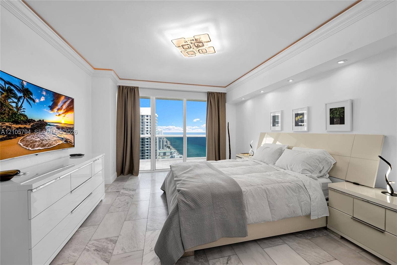 1830 S Ocean Drive, #4210, Hallandale Beach, Hallandale Beach, FL 33009 Floor-to-ceiling glass panel windows, stone-finish tile flooring, recessed ceiling lighting, decorative crown molding, and built-in soffit lighting