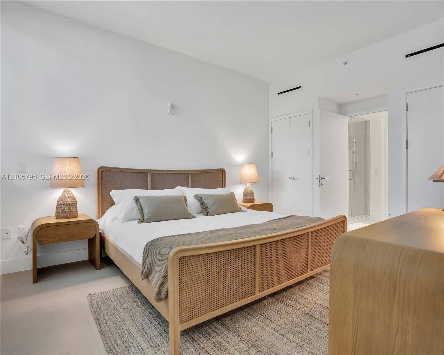407 N Riverside Drive, #202, Pompano Beach, Pompano Beach, FL 33062 Minimalist room featuring neutral-tone ceramic tile flooring, smooth white walls, and a pair of floor-to-ceiling double-door closets
