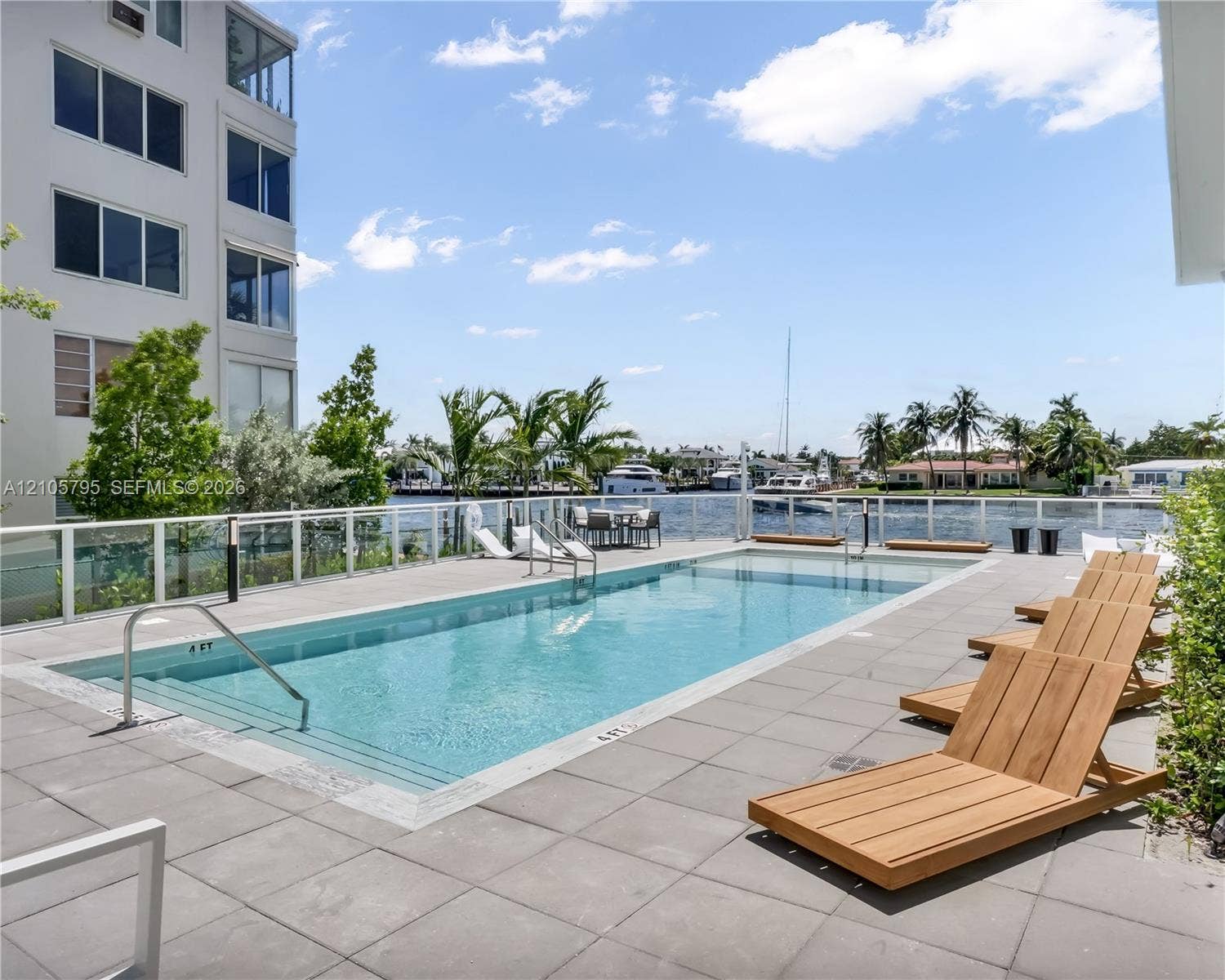 407 N Riverside Drive, #202, Pompano Beach, Pompano Beach, FL 33062 Swimming pool with a tile deck and a glass-panel railing overlooking the water