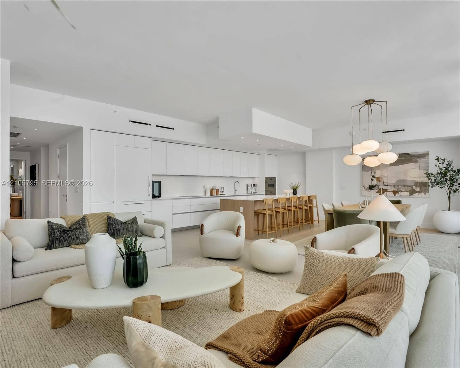 407 N Riverside Drive, #202, Pompano Beach, Pompano Beach, FL 33062 Open-concept kitchen featuring integrated white cabinetry, a center island with wood-finish paneling, built-in appliances, recessed lighting, and a multi-pendant light fixture