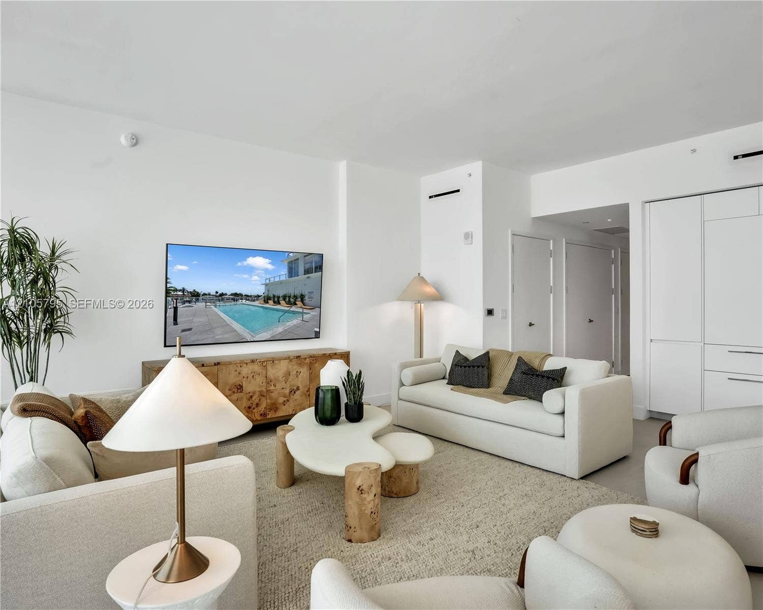 407 N Riverside Drive, #202, Pompano Beach, Pompano Beach, FL 33062 Living area featuring high ceilings, light-toned flooring, recessed lighting, and integrated wall cabinetry