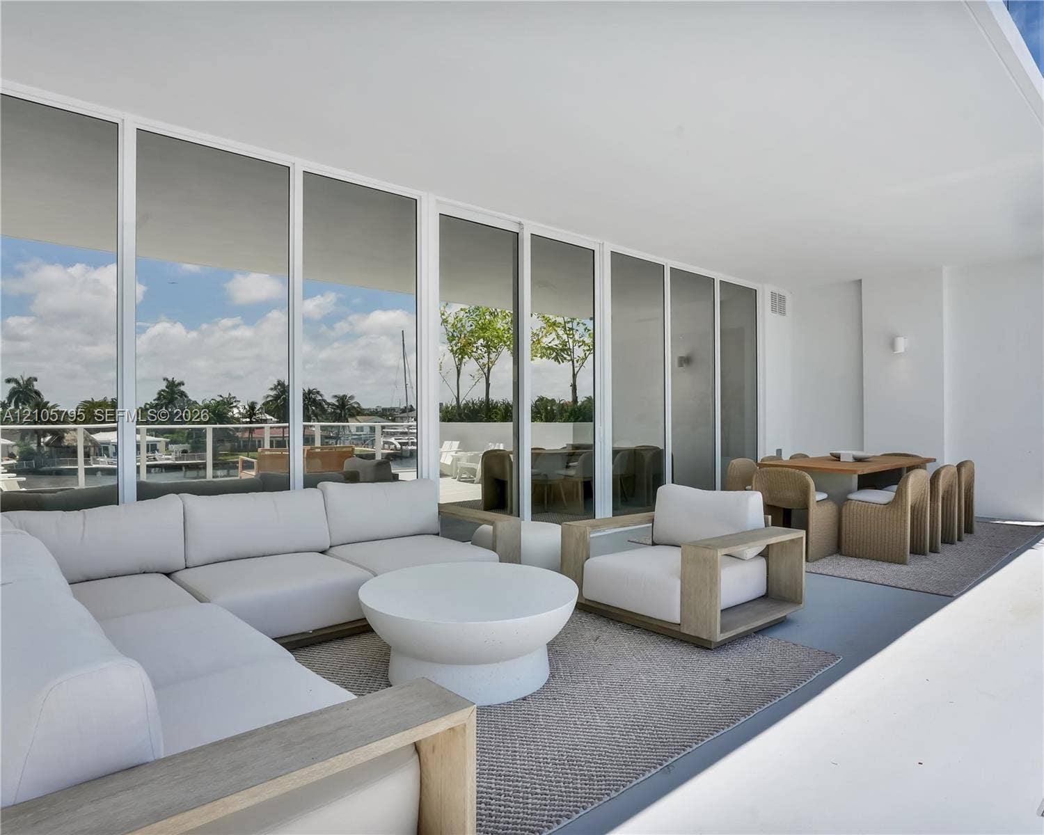 407 N Riverside Drive, #202, Pompano Beach, Pompano Beach, FL 33062 Covered terrace featuring floor-to-ceiling glass wall panels, minimalist structural columns, and a smooth, level ceiling finish