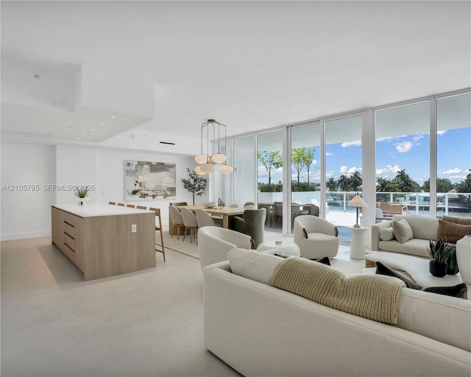 407 N Riverside Drive, #202, Pompano Beach, Pompano Beach, FL 33062 Open-concept living space featuring floor-to-ceiling glass panels, a central kitchen island with a light-toned wood finish and solid surface countertop, polished flooring, and recessed lighting