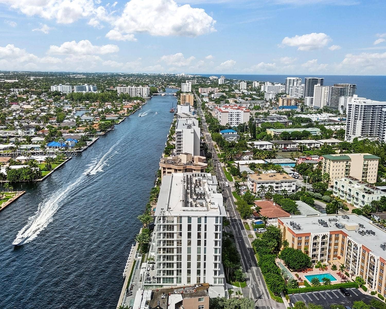 407 N Riverside Drive, #202, Pompano Beach, Pompano Beach, FL 33062 Aerial perspective featuring expansive waterway frontage, multi-story coastal structures, and mature palm tree landscaping