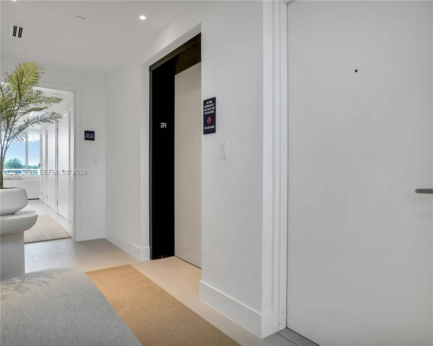 407 N Riverside Drive, #202, Pompano Beach, Pompano Beach, FL 33062 Hallway featuring smooth white walls, recessed ceiling lighting, light-toned flooring, and a dedicated elevator access point