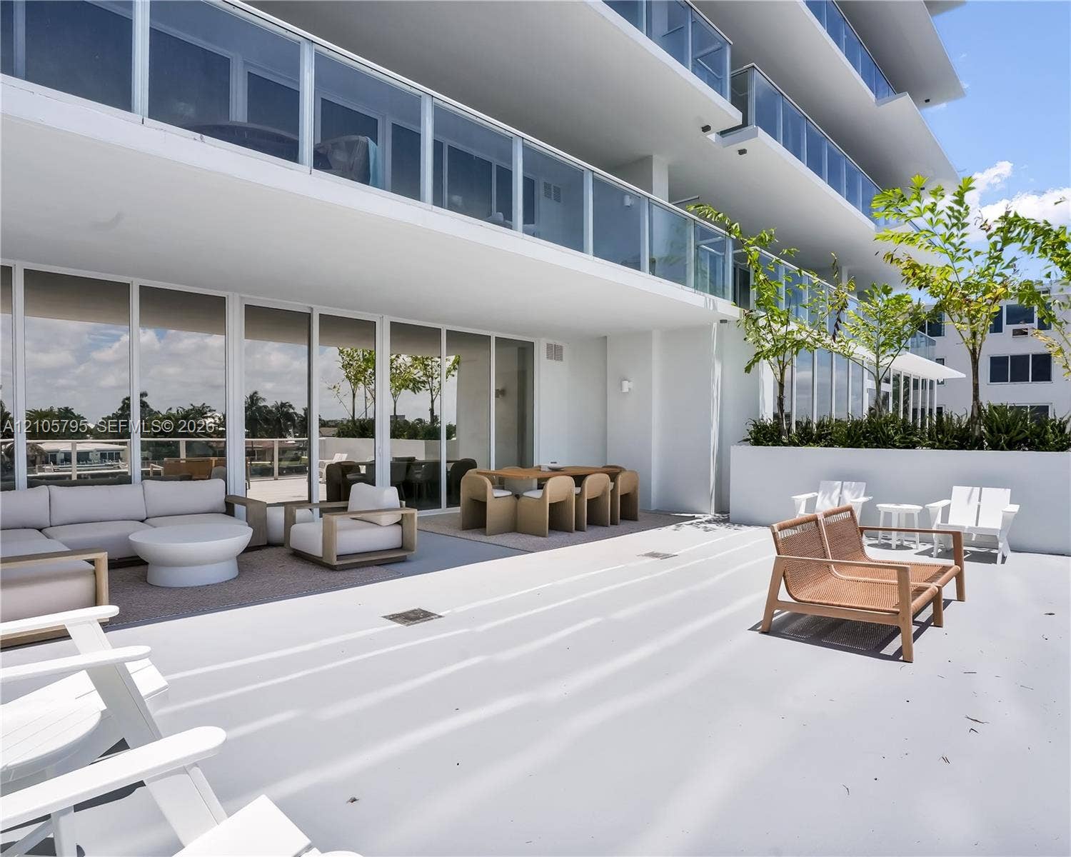 407 N Riverside Drive, #202, Pompano Beach, Pompano Beach, FL 33062 Expansive covered terrace featuring floor-to-ceiling glass doors, sleek glass balcony railings, a concrete floor surface, and integrated built-in planters