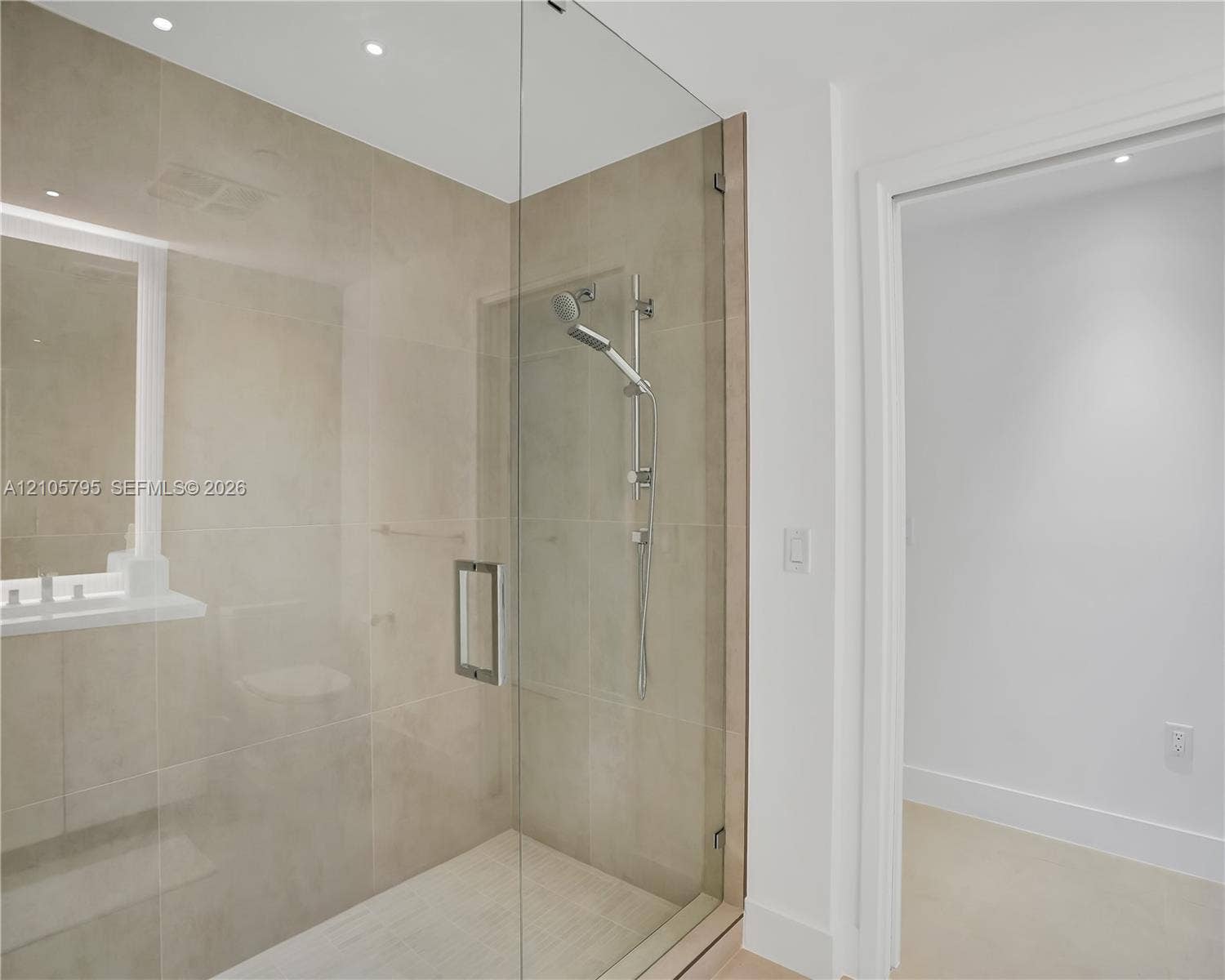 407 N Riverside Drive, #202, Pompano Beach, Pompano Beach, FL 33062 Walk-in shower featuring large-format neutral wall tile, a glass enclosure, an adjustable-height handheld showerhead, and recessed lighting