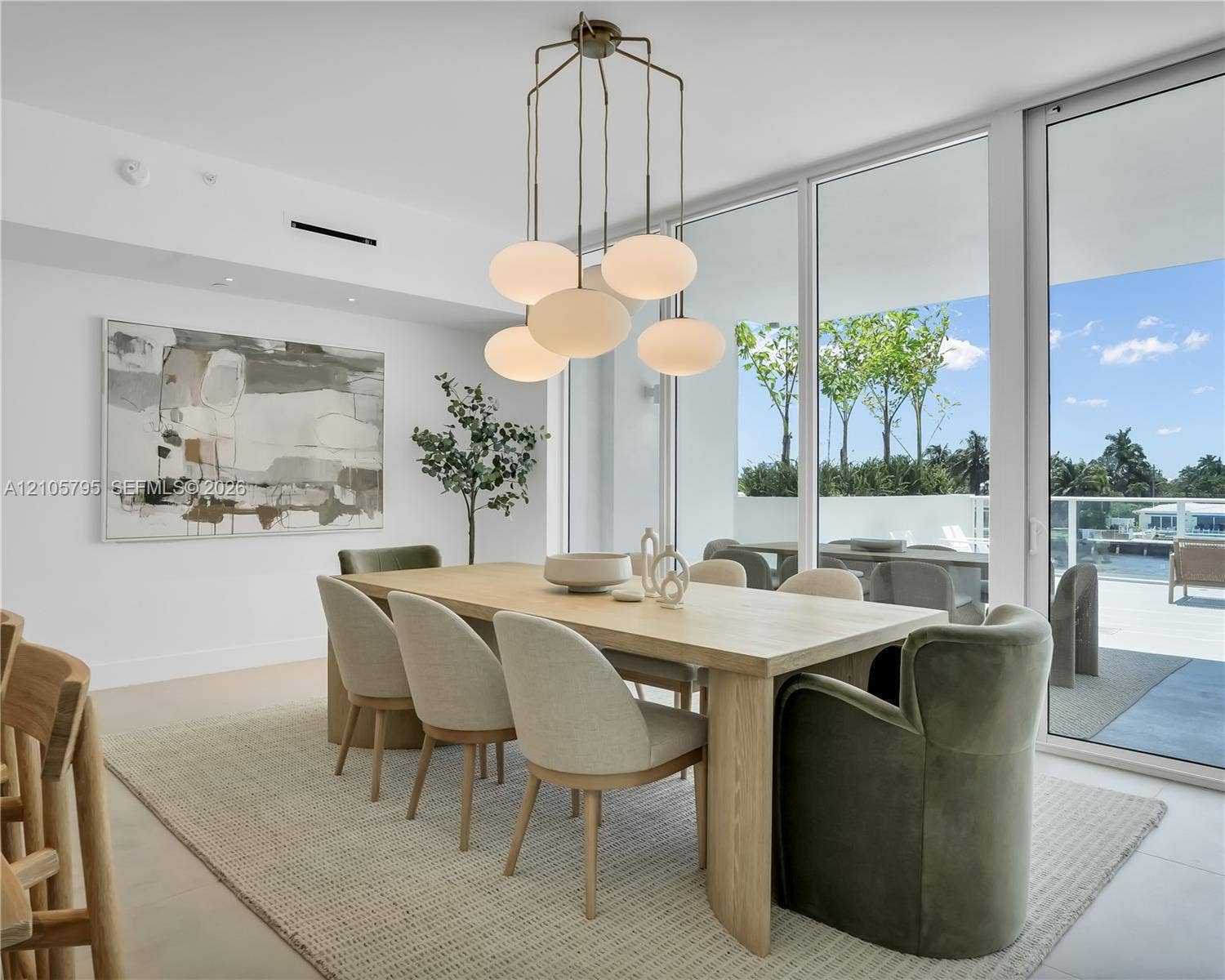 407 N Riverside Drive, #202, Pompano Beach, Pompano Beach, FL 33062 Floor-to-ceiling glass walls, multi-pendant opal glass lighting fixture, and light-toned flooring