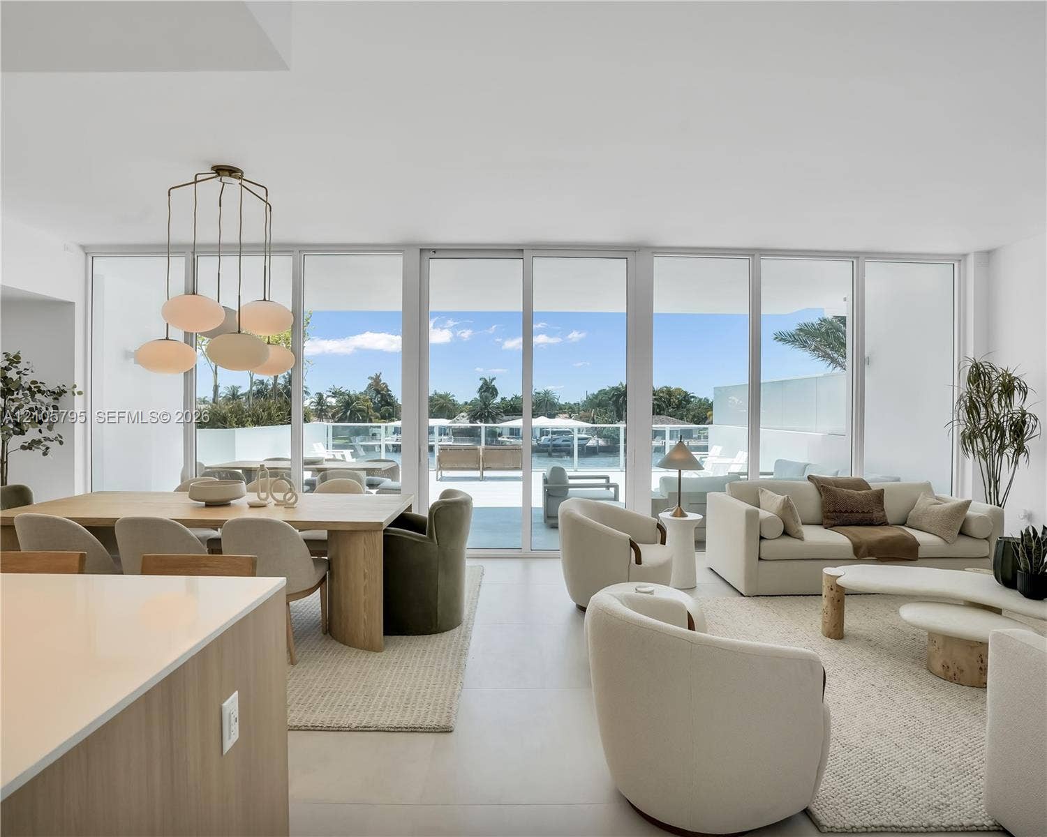 407 N Riverside Drive, #202, Pompano Beach, Pompano Beach, FL 33062 Floor-to-ceiling glass panel walls, polished neutral-toned tile flooring, and a multi-pendant modern light fixture