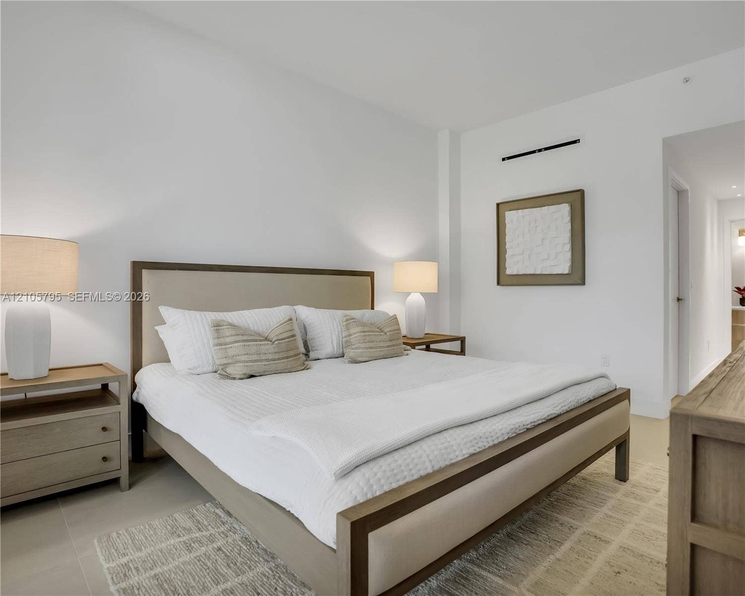 407 N Riverside Drive, #202, Pompano Beach, Pompano Beach, FL 33062 Neutral-toned interior featuring smooth wall surfaces, high ceilings, large-format tile flooring, and a wall-mounted climate control unit