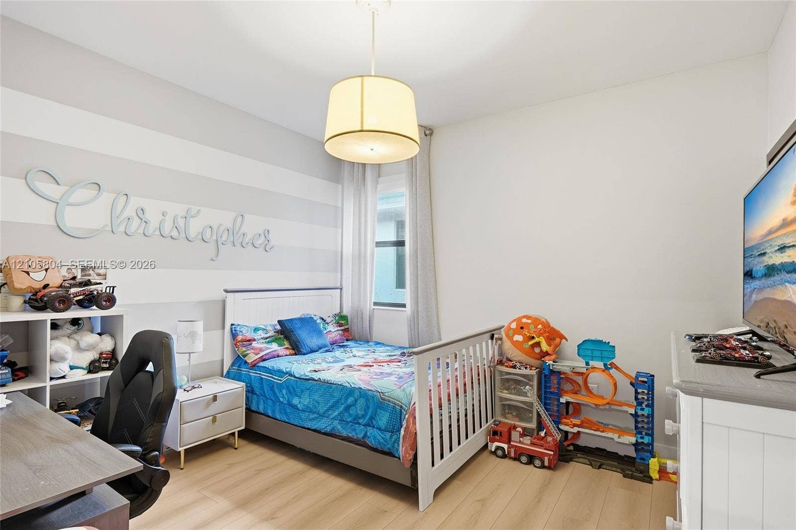15932 SW 136th Way, Miami, FL 33196 Room featuring light-toned wood-finish flooring, a drum pendant light fixture, a window with vertical blinds, and a horizontal-striped accent wall
