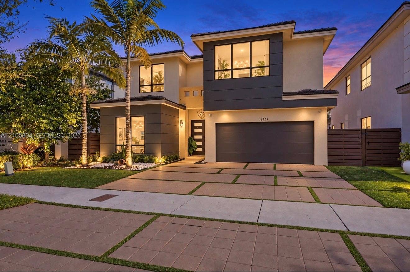 15932 SW 136th Way, Miami, FL 33196 Two-story contemporary exterior featuring stucco siding, multi-pane picture windows, a paved geometric driveway, and an attached two-car garage
