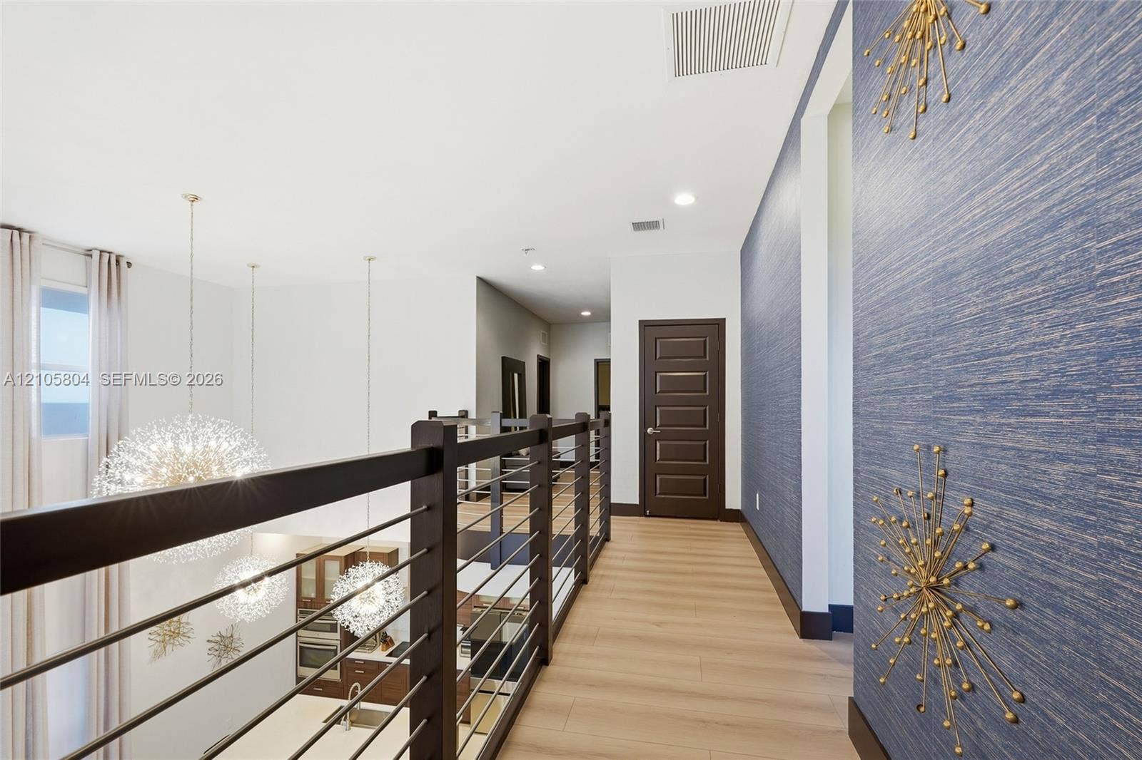 15932 SW 136th Way, Miami, FL 33196 Upper-level walkway featuring wood-finish flooring, a contemporary horizontal cable railing system, textured blue wall covering, and recessed lighting