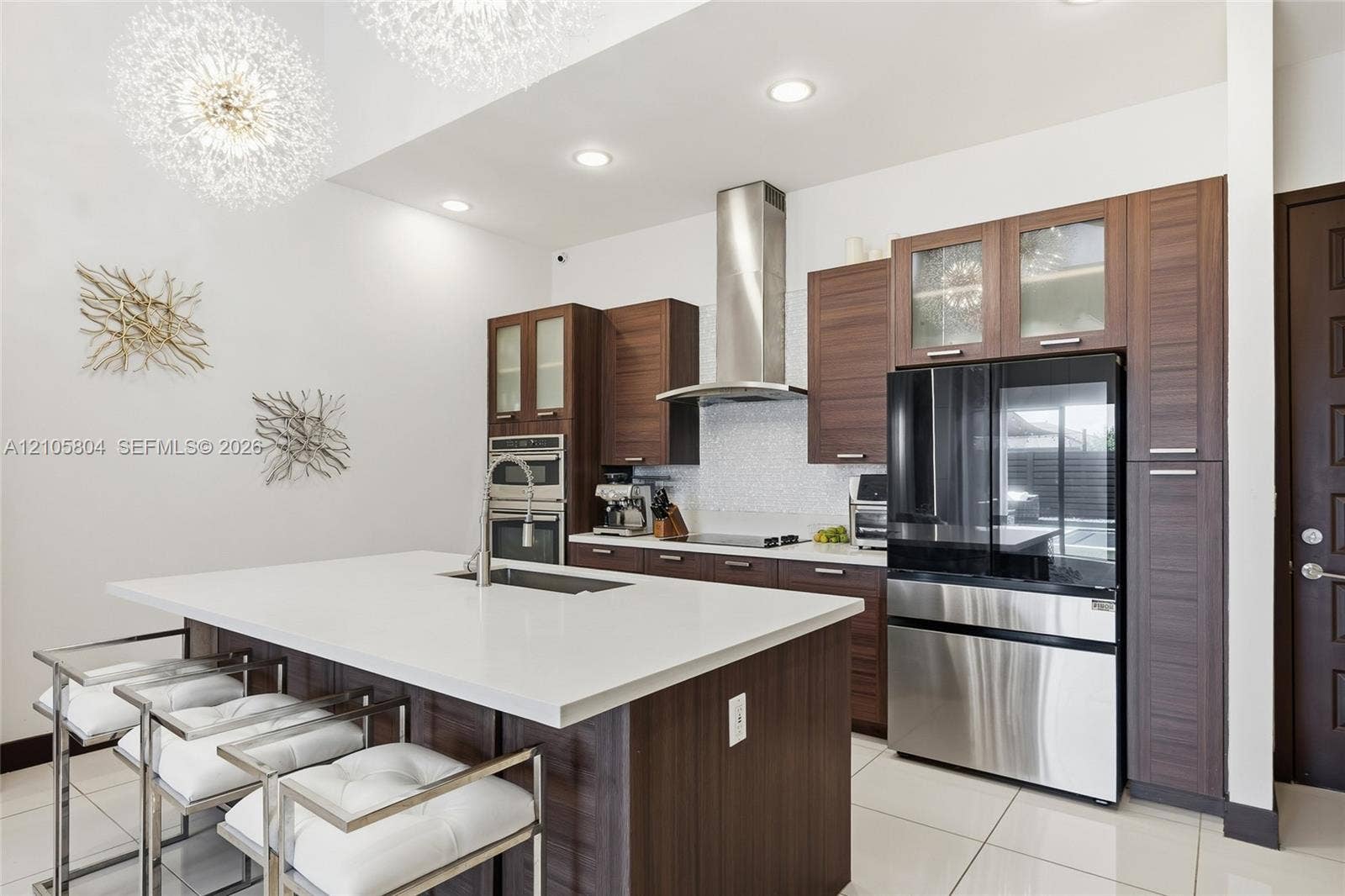 15932 SW 136th Way, Miami, FL 33196 Kitchen featuring custom wood-finish cabinetry, a large central island with a quartz countertop, stainless steel appliances, a glass-tile backsplash, and recessed lighting