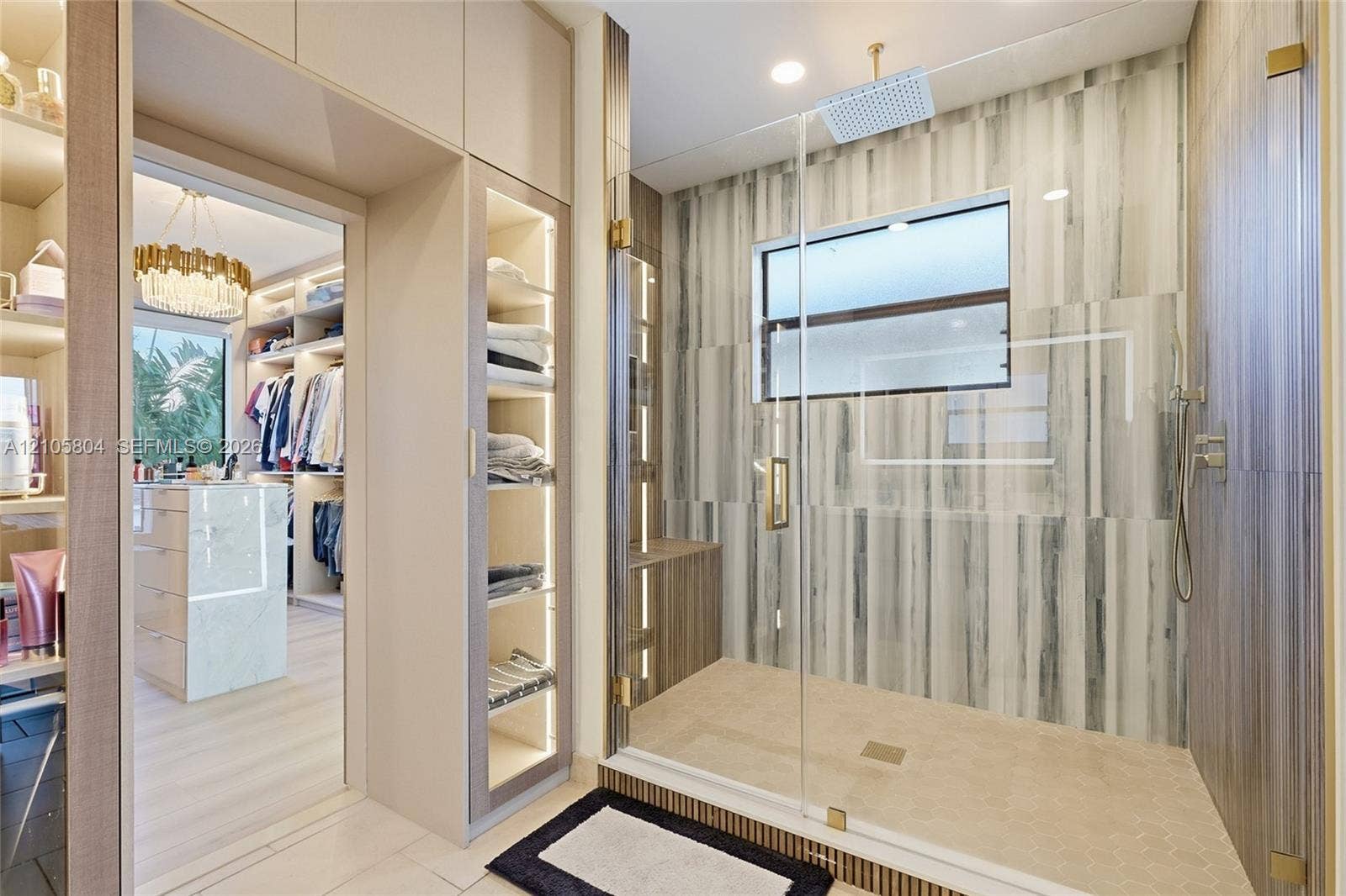 15932 SW 136th Way, Miami, FL 33196 Walk-in shower with floor-to-ceiling tiled walls, glass enclosure, and rainfall showerhead, complemented by custom built-in cabinetry with integrated lighting