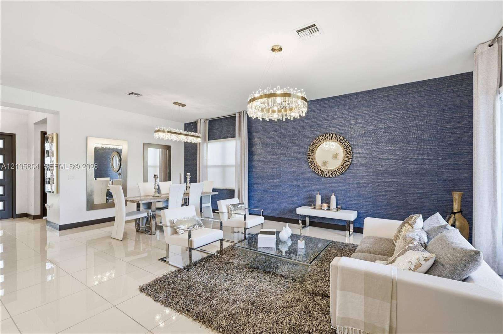 15932 SW 136th Way, Miami, FL 33196 Polished tile flooring, textured navy blue accent wall, and two multi-tiered crystal chandeliers
