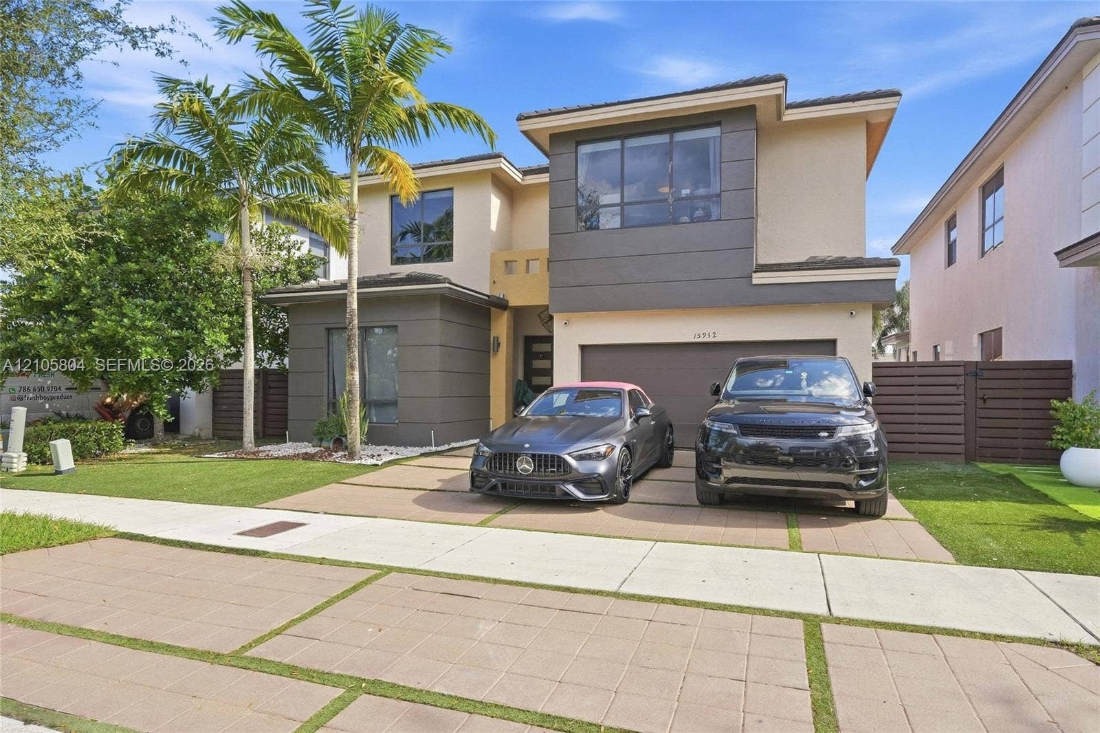 15932 SW 136th Way, Miami, FL 33196 Contemporary two-story exterior featuring a multi-toned stucco facade, paver driveway with turf accents, mature palm trees, and an attached two-car garage