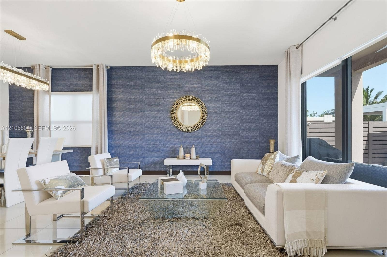 15932 SW 136th Way, Miami, FL 33196 Textured blue accent wall featuring a contemporary crystal drum chandelier, large-format tile flooring, and oversized windows